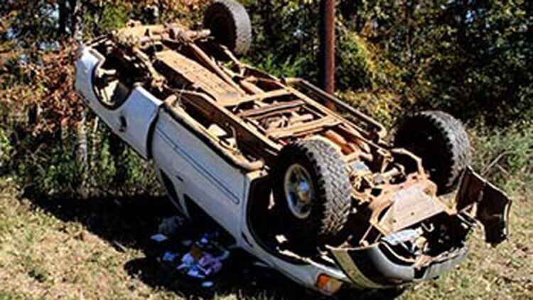 Marines with Bravo Company, 1st Battalion, 23rd Marine Regiment, 4th Marine Division, were the first on the scene of this overturned truck Nov. 26, 2014, after conducting a funeral detail. The woman inside, Patti Cranford, of Garrison, Texas, was on her way to the funeral when she lost control of her vehicle a mile away from the cemetery. (Photo by Scott Flowers)