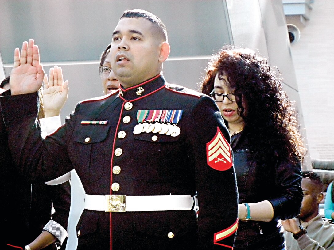 Sgt. Gustavo Antonio Arroliga-Lopez, a  Marine recruiter in Woodbridge and a native of Nicaragua, takes the Oath of Citizenship along with other new citizens during last month’s Naturalization Ceremony at the National Museum of the Marine Corps last month.