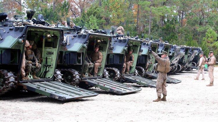 Marines with the Amphibious Assault Vehicle Platoon, Company B, Ground Combat Element Integrated Task Force, supervise the closing of the ramps on the AAVs in preparation to depart the French Creek loading dock at Marine Corps Base Camp Lejeune, North Carolina, Dec. 2, 2014. Marines with AAV Platoon, Company B, GCEITF, transported Co. A Marines to the Verona Loop training area on Camp Lejeune to conduct a three-day live-fire training event with the M27 Infantry Automatic Rifle. 