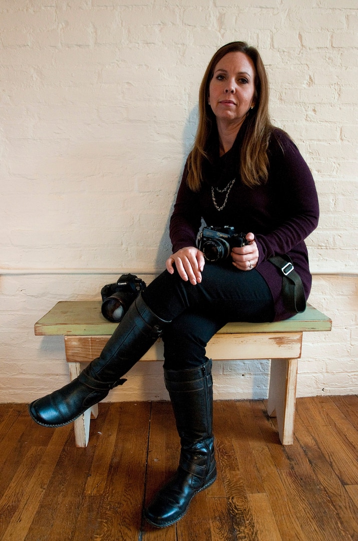 Angela Powell-Woulfe, a military suicide survivor whose father ended his life in 2004, poses for a photo in her photo studio Nov. 12, 2014, in Savage, Md. Powell-Woulfe has used their shared love of photography to cope with the sudden loss of her father, which she continues to struggle with on a daily basis. 