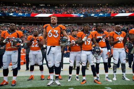 U.S. Air Force Capt. Ben Garland (63), 140th Wing Pubic Affairs, Colorado Air National Guard, and offensive lineman with the Denver Broncos, stands at attention during the national anthem at Sports Authority Field at Mile High, where the Denver Broncos hosted the Miami Dolphins, Nov. 23, 2014. Garland is playing in his first official home game with the Denver Broncos, having also played in the past two away games for Denver this season.