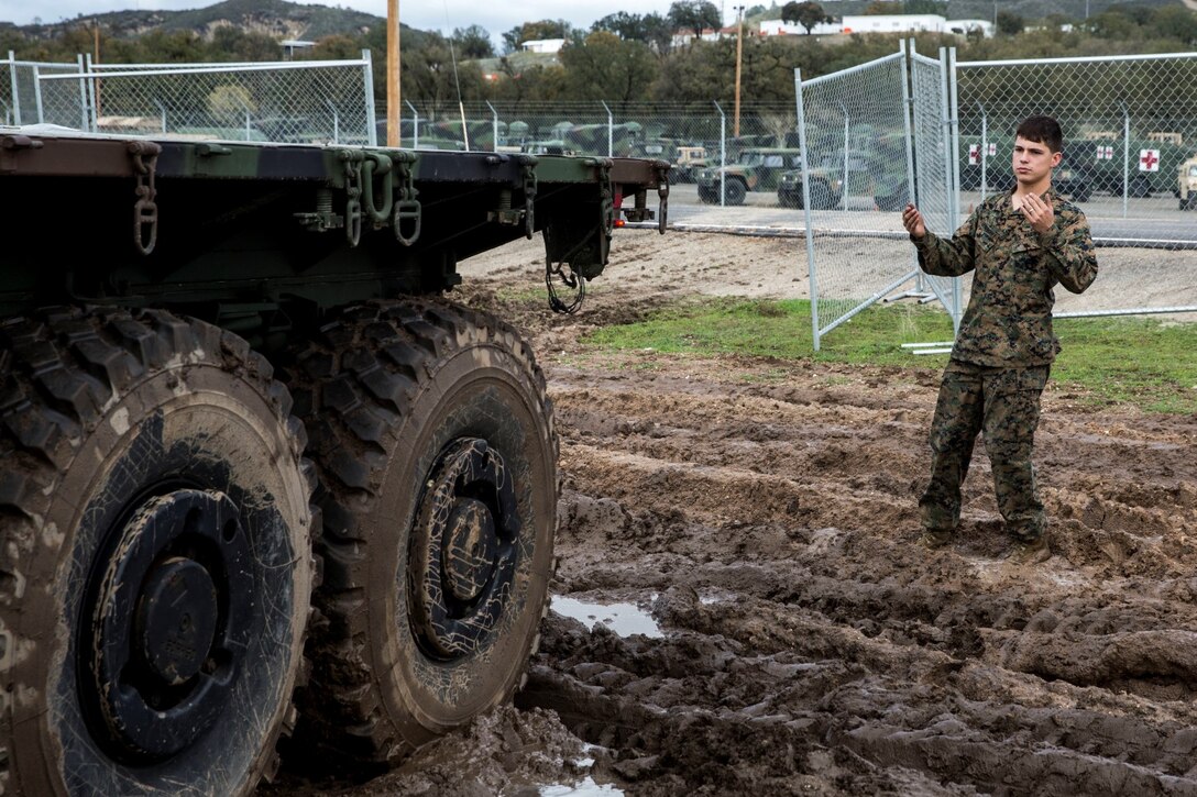 U.S. Marine Lance Cpl. Jose Dominguez guides a Medium Tactical Vehicle Replacement during realistic urban training aboard Fort Hunter Liggett, Calif., Dec. 6, 2014. Dominguez is a motor transportation mechanic with Combat Logistics Battalion 15, 15th Marine Expeditionary Unit. The purpose of RUT is to provide the MEU an opportunity to conduct training in unfamiliar environments in preparation for their upcoming deployment. (U.S. Marine Corps photo by Cpl. Anna Albrecht/Released)