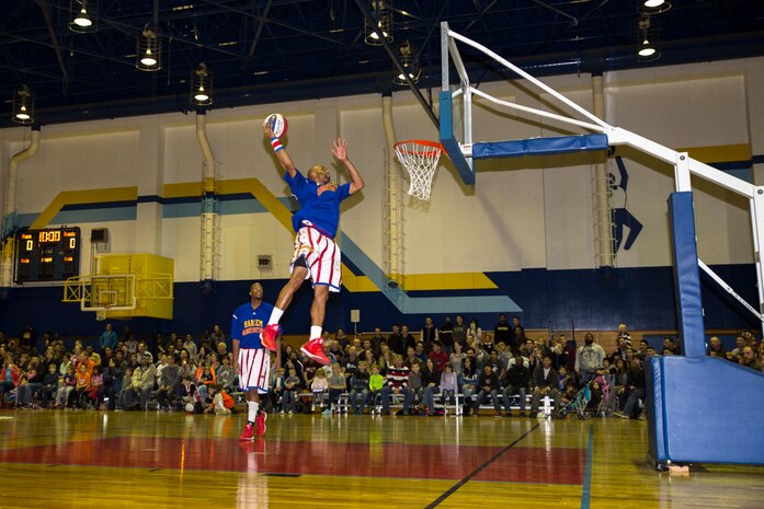 Hawk Thomas, a player with the Harlem Globetrotters, goes for a dunk during warm-ups inside the IronWorks Gymnasium aboard Marine Corps Air Station Iwakuni, Japan, Dec. 7, 2014. The team is doing their 13th tour in 11 years, made possible by Navy Entertainment and Armed Forces Entertainment.