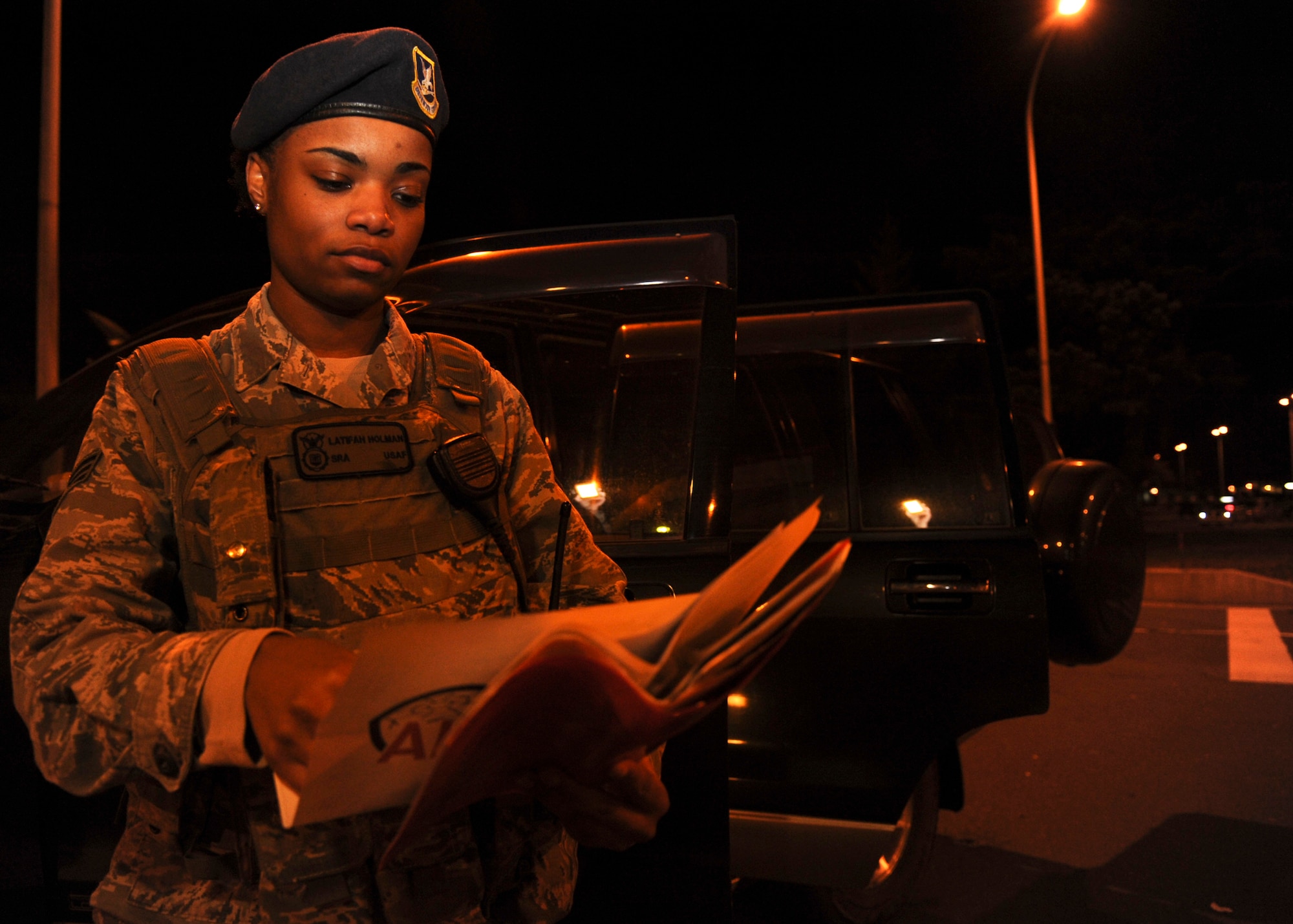 Senior Airman Latifah Holman, 35th Security Forces Squadron alarm monitor, reviews vehicle documents during a random vehicle check at Misawa Air Base, Japan, Nov. 20, 2014. As a member of the SFS, Holman is responsible for enusring the safety of Misawa personnel and equipment. Her superior performance, outstanding work ethic, and overall good conduct and discipline earned her the title of Wild Weasel of the Week. (U.S. Air Force photo/Staff Sgt. Alyssa C. Wallace)
