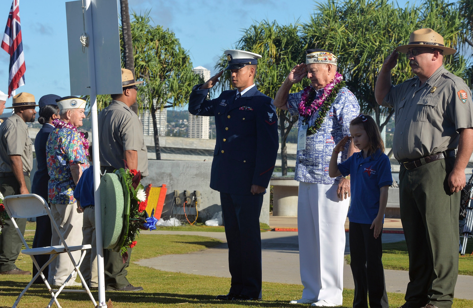 U.S. Coast Guard Petty Officer 3rd Class Kelvin Andrews, assigned to the 14th Coast Guard District, Louis Conter, a survivor of the Dec. 7, 1941 Japanese attack on Pearl Harbor, Audrey Leong, a student at the Navy Hale Keiki School, and Kary Goetz, a National Park Service ranger, present a wreath during the 73rd anniversary Pearl Harbor Day commemoration ceremony at the Pearl Harbor Visitor Center. More than 2,000 guests, including Pearl Harbor survivors and other veterans, attended the National Park Service and U.S. Navy hosted joint memorial ceremony at the World War II Valor in the Pacific National Monument. This year's theme focused on "Preserving the Memory." (U.S. Navy photo by Mass Communication Specialist 2nd Class Laurie Dexter/Released)