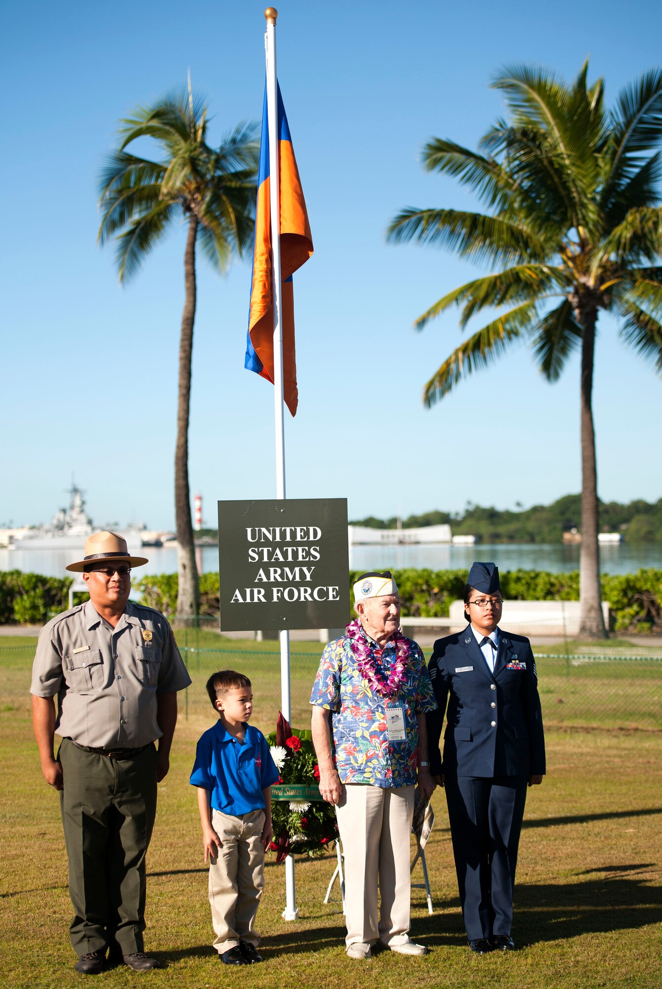 From left, Ranger Stephen CamCam, Isaac Canfield, a student at the Navy Hale Keiki School, Cmdr. (retired) John Mathrusse, Pearl Harbor survivor, and U.S. Air Force Staff Sgt. Wagner give their respect after presenting a U.S. Air Force wreath during the 73rd Anniversary Pearl Harbor Day commemoration ceremony at the Pearl Harbor Visitor Center, Hawaii, Dec. 7, 2014. More than 2,000 guests, including Pearl Harbor survivors and other veterans, attended the National Park Service and U.S. Navy-hosted joint memorial ceremony at the World War II Valor in the Pacific National Monument. This year's theme focused on "Preserving the Memory." (U.S. Navy photo by Mass Communication Specialist 2nd Class Diana Quinlan/Released)
