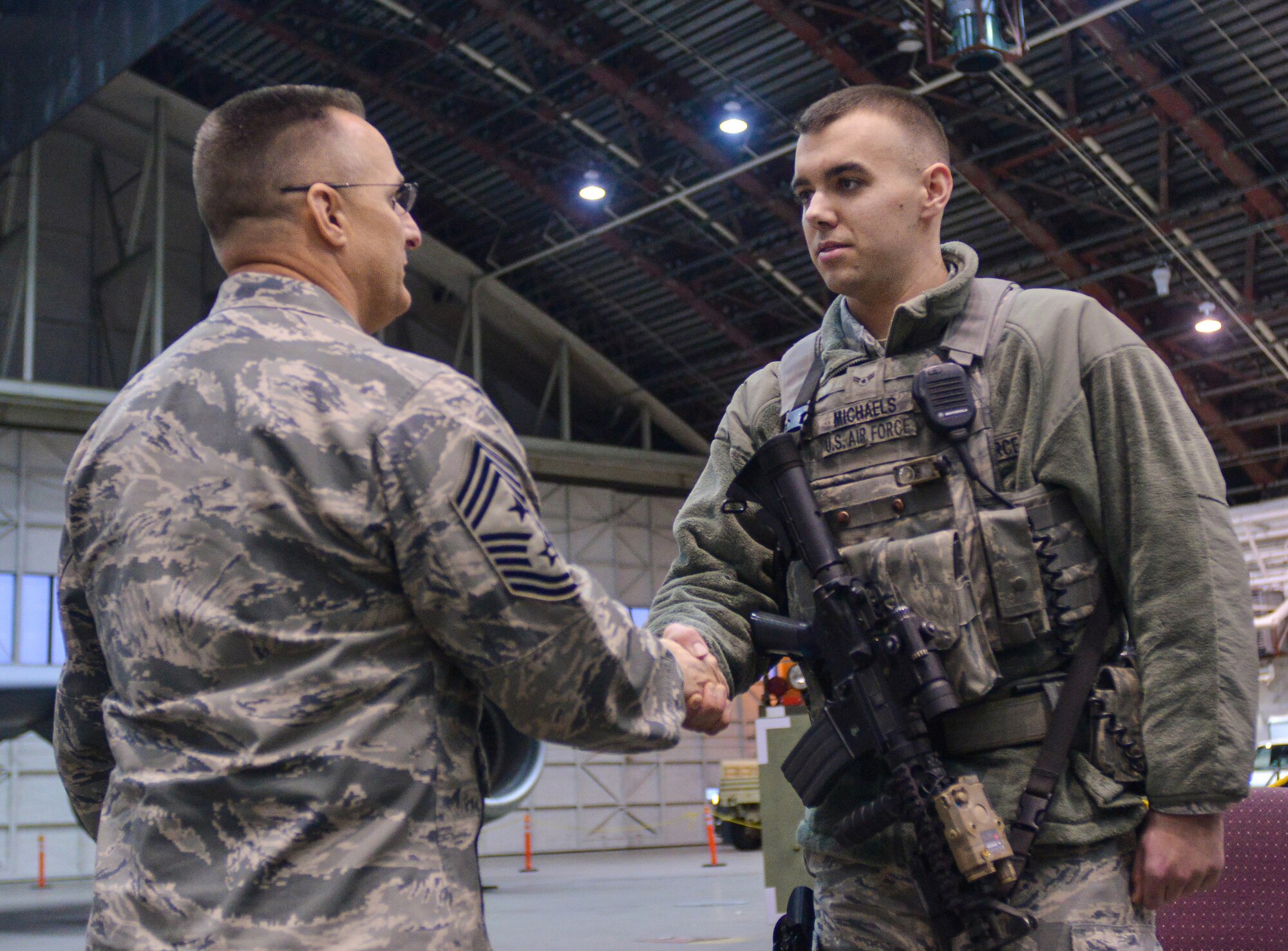 Chief Master Sgt. Buddy Hutchison, the PACAF command chief, coins Airman
1st Class Sean Michaels, assigned to the 354th Security Forces Squadron,
during a visit to Eielson Air Force Base, Dec. 4, 2014. During his visit to
Eielson, Chief Hutchison visited Airmen and families and witnessed Eielson
missions and operations with Gen. Lori Robinson, the Pacific Air Forces
commander.  (U.S. Air Force photo by Tech. Sgt. Joseph Swafford/Released)
