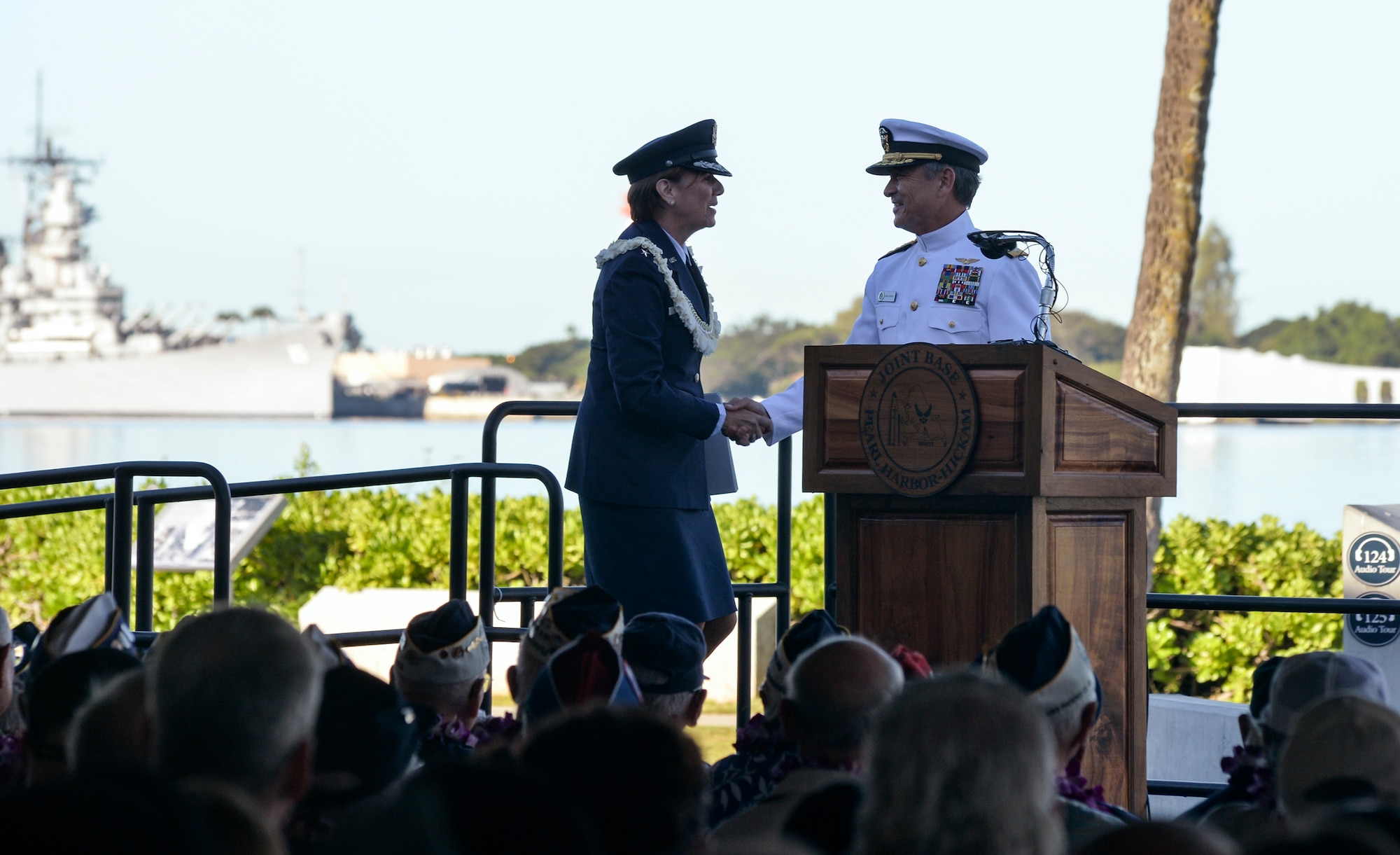 U.S. Air Force Gen. Lori J. Robinson, Pacific Air Forces commander, (left) and Adm. Harry B. Harris Jr., commander of U.S. Pacific Fleet, shake hands during the 73rd Anniversary Pearl Harbor Day commemoration ceremony at the Pearl Harbor Visitor Center, Dec. 7, 2014. More than 2,000 guests, including Pearl Harbor survivors and other veterans, attended the National Park Service and U.S. Navy hosted joint memorial ceremony at the World War II Valor in the Pacific National Monument. This year's theme focused on "Preserving the Memory." (U.S. Navy photo by Mass Communication Specialist 2nd Class Laurie Dexter/Released)

