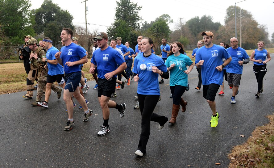 Members of the Bell family and Team Barksdale rally around 2nd Civil Engineer Squadron Explosive Ordnance Disposal Airmen for the last leg of the SrA Bryan R. Bell 5K Memorial Run and crossed the finish line together on Barksdale Air Force Base, La., Dec. 5, 2014. The run honored Bell, who gave his life defending his country in Afghanistan in 2012 in support of Operation Enduring Freedom.  (U.S. Air Force photo/Airman 1st Class Curt Beach)