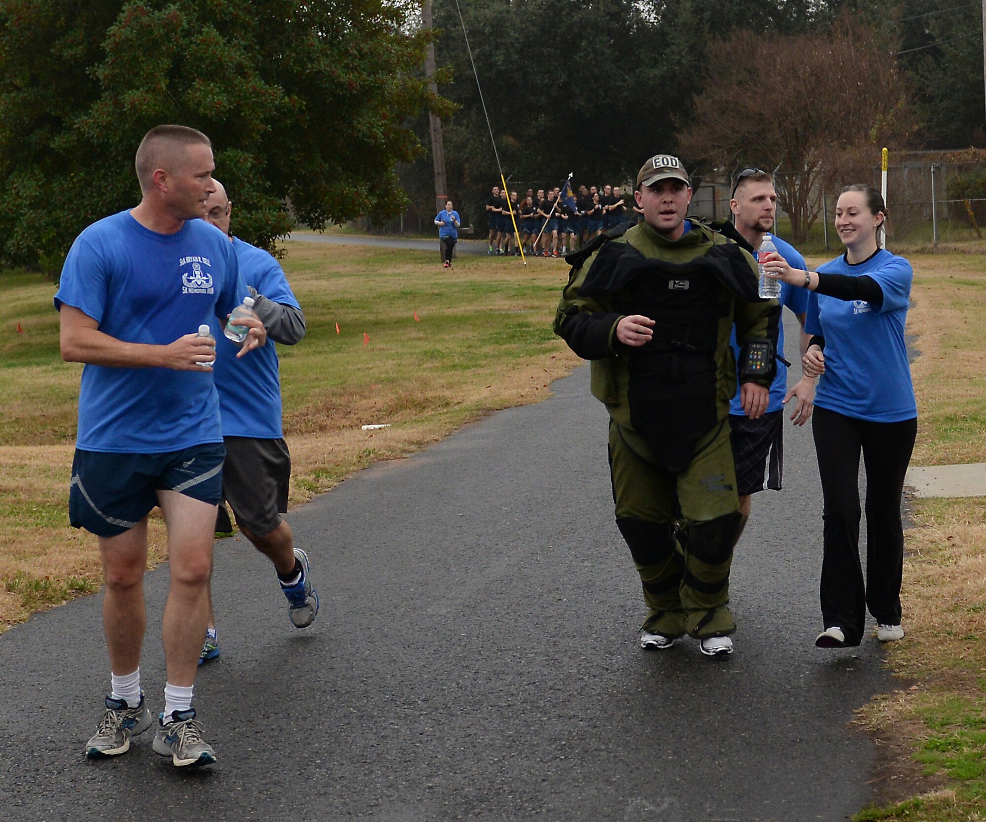 Alaina Bell, widow of the late Senior Airman Bryan Bell, offers water to Staff Sgt. Jordan Burger, 2nd Civil Engineer Squadron Explosive Ordnance Disposal technician, as he prepares to enter the final leg of the first SrA Bryan R. Bell 5K Memorial Run on Barksdale Air Force Base, La., Dec. 5, 2014. Bell, 2 CES EOD technician, tragically lost his life from injuries sustained when his vehicle struck an improvised explosive device while supporting Operation Enduring Freedom in Afghanistan Jan. 5, 2012. (U.S. Air Force photo/Airman 1st Class Curt Beach)