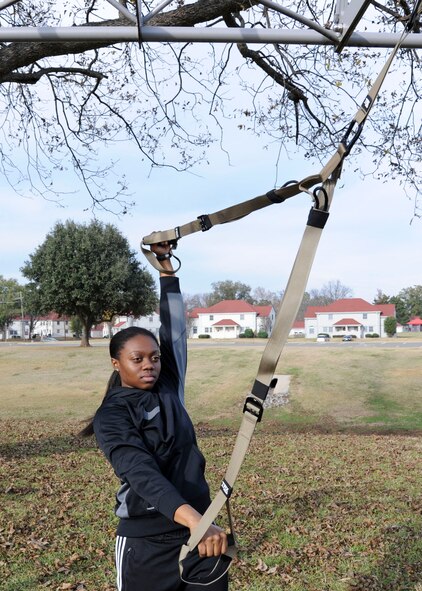 Senior Airman Ashley Thompson, 2nd Communications Squadron network operations technician, demonstrates the split fly exercise from a new resistance training program on Barksdale Air Force Base, La., Dec. 7, 2014. The Barksdale Fitness Center has added 18 group aerobic exercise classes along with the new program to stay current with the latest workouts. (U.S. Air Force photo/ Senior Airman Jannelle Dickey)