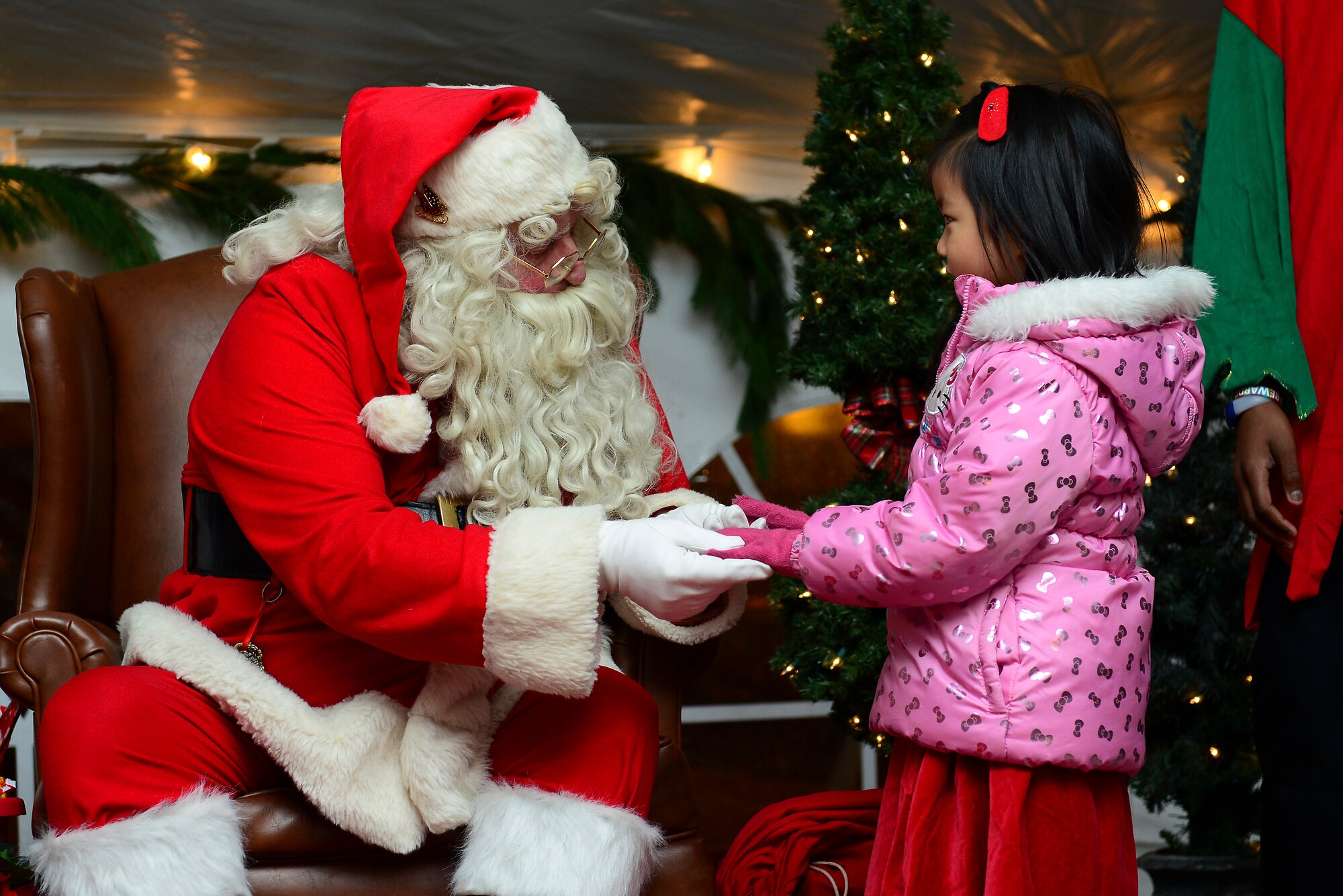 Mary Hong, 5, daughter of U.S. Army Sgt. David Hong, Fort Eustis chaplain assistant, meets with Santa during the 59th Annual Christmas Tree lighting at Fort Eustis, Va., Dec. 5, 2014. After the tree was lit ceremony goers had the chance to meet with Mr. and Mrs. Claus and participate in other event activities such as different arts-and-craft projects. (U.S. Air Force photo by Senior Airman Kimberly Nagle/Released)