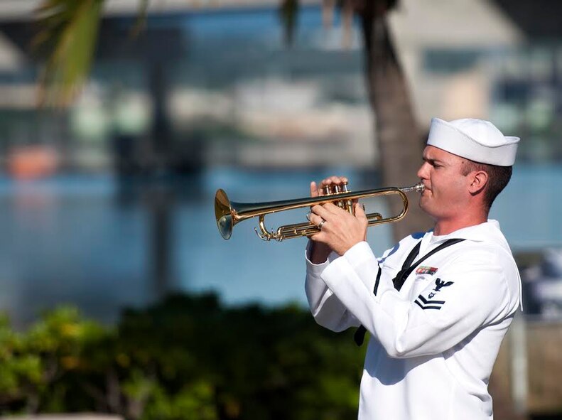 A Sailor, assigned to the Pacific Fleet Band, performs taps during the 73rd Anniversary Pearl Harbor Day commemoration ceremony at the Pearl Harbor Visitor Center, Hawaii, Dec. 7, 2014. More than 2,000 guests, including Pearl Harbor survivors and other veterans, attended the National Park Service and U.S. Navy-hosted joint memorial ceremony at the World War II Valor in the Pacific National Monument. This year's theme focused on "Preserving the Memory." (U.S. Navy photo by Mass Communication Specialist 2nd Class Diana Quinlan/Released))