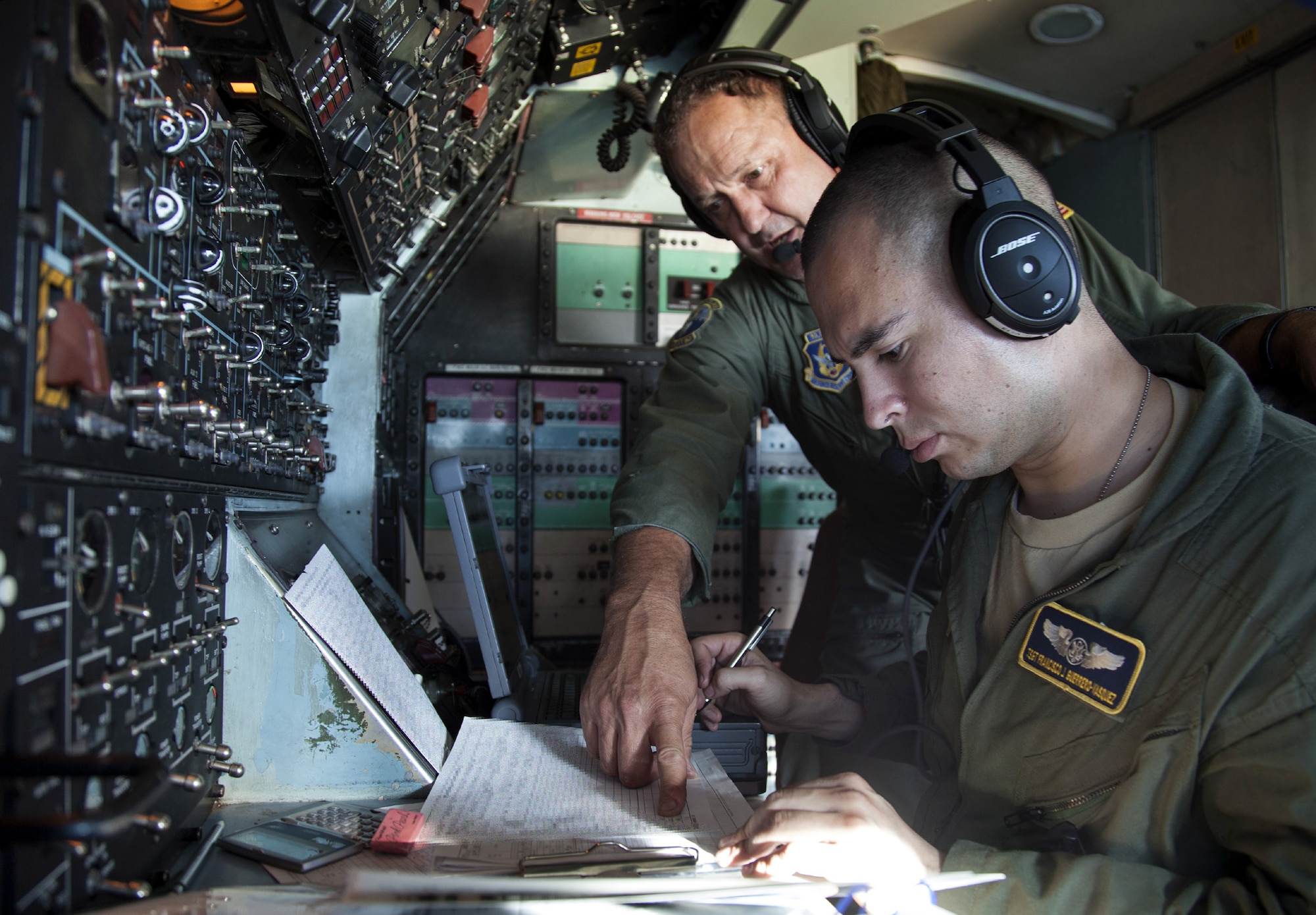 TRAVIS AIR FORCE BASE, Calif. --Senior Master Sgt. Timothy Nichols (left), flight engineer evaluator, discusses fuel consumption with Tech. Sgt. Francisco Guerrero-Vasquez, flight engineer, on the flight deck of a C-5B Galaxy on a Pacific channel mission.  Both Air Force Reserve aviators are assigned to the 312th Airlift Squadron, Travis Air Force Base, Calif. (U.S. Air Force photo/Lt. Col. Robert Couse-Baker)
