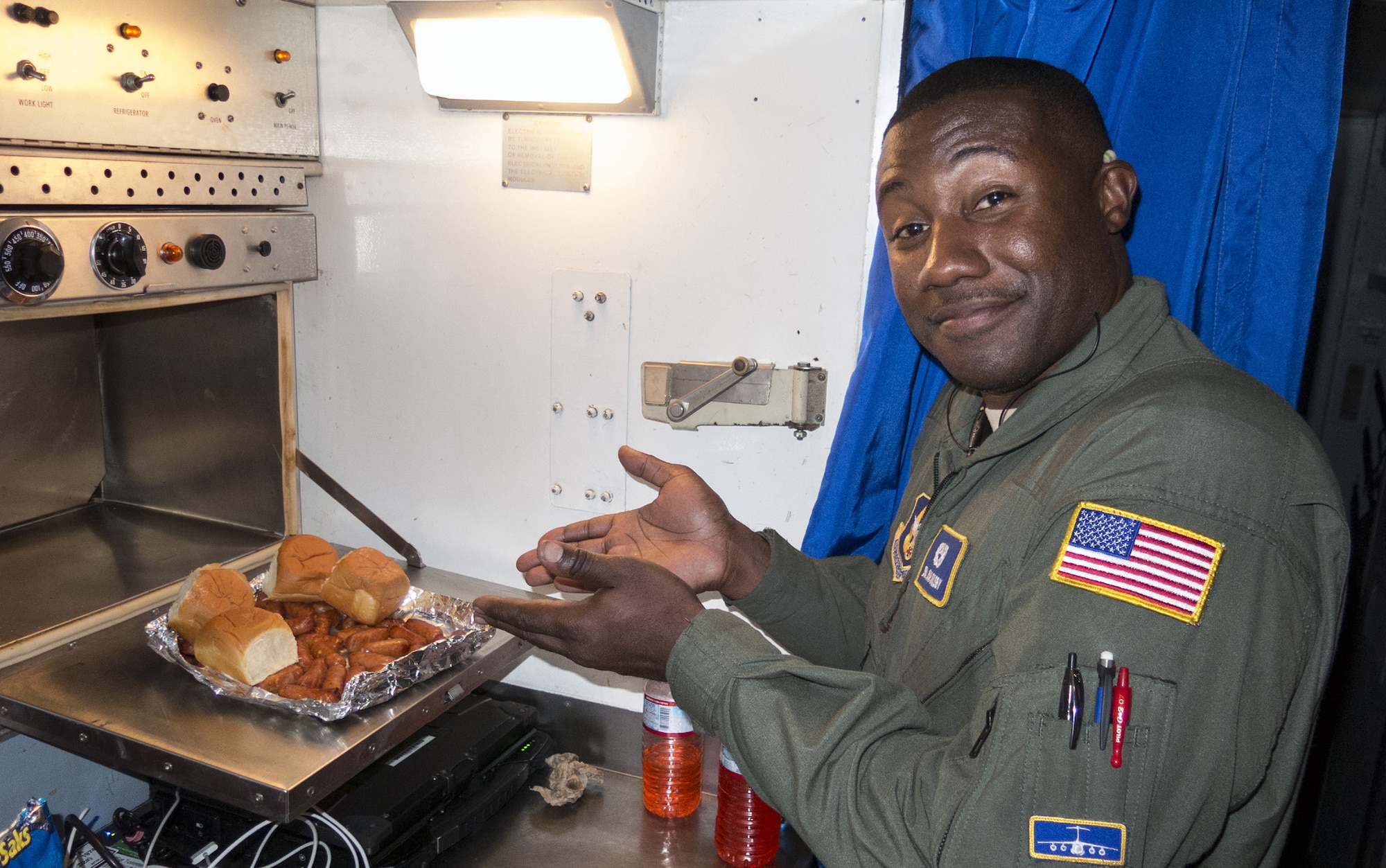 TRAVIS AIR FORCE BASE, Calif. --Senior Airman Isiah Crosby, crew chief, 349th Aircraft Maintenance Squadron, demonstrates the versatility of in-flight cooking in the galley of a C-5B Galaxy during a Pacific channel mission, Aug. 12, 2014.  Good nutrition and hydration keep aircrew and maintainers at peak efficiency on the long duty days and dynamic schedules required for trans-oceanic mobility flights. (U.S. Air Force photo/Lt. Col. Robert Couse-Baker)