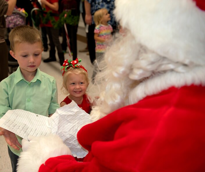 Corbyn and Emily Schuler present their wish list to Santa during Eglin’s traditional Christmas tree lighting ceremony at the West Gate Chapel Dec. 5. Capt. Micah Baker, chaplain, led the festivities with a moment of prayer.  During the base event, the winner of the base life-sized card decoration contest was announced.  Brig. Gen. David Harris, 96th Test Wing commander also addressed the crowd with messages of peace and goodwill before lighting the tree. The chapel sponsored a reception with entertainment and refreshments after Santa Claus arrived by fire truck. (U.S. Air Force photo/Ilka Cole)