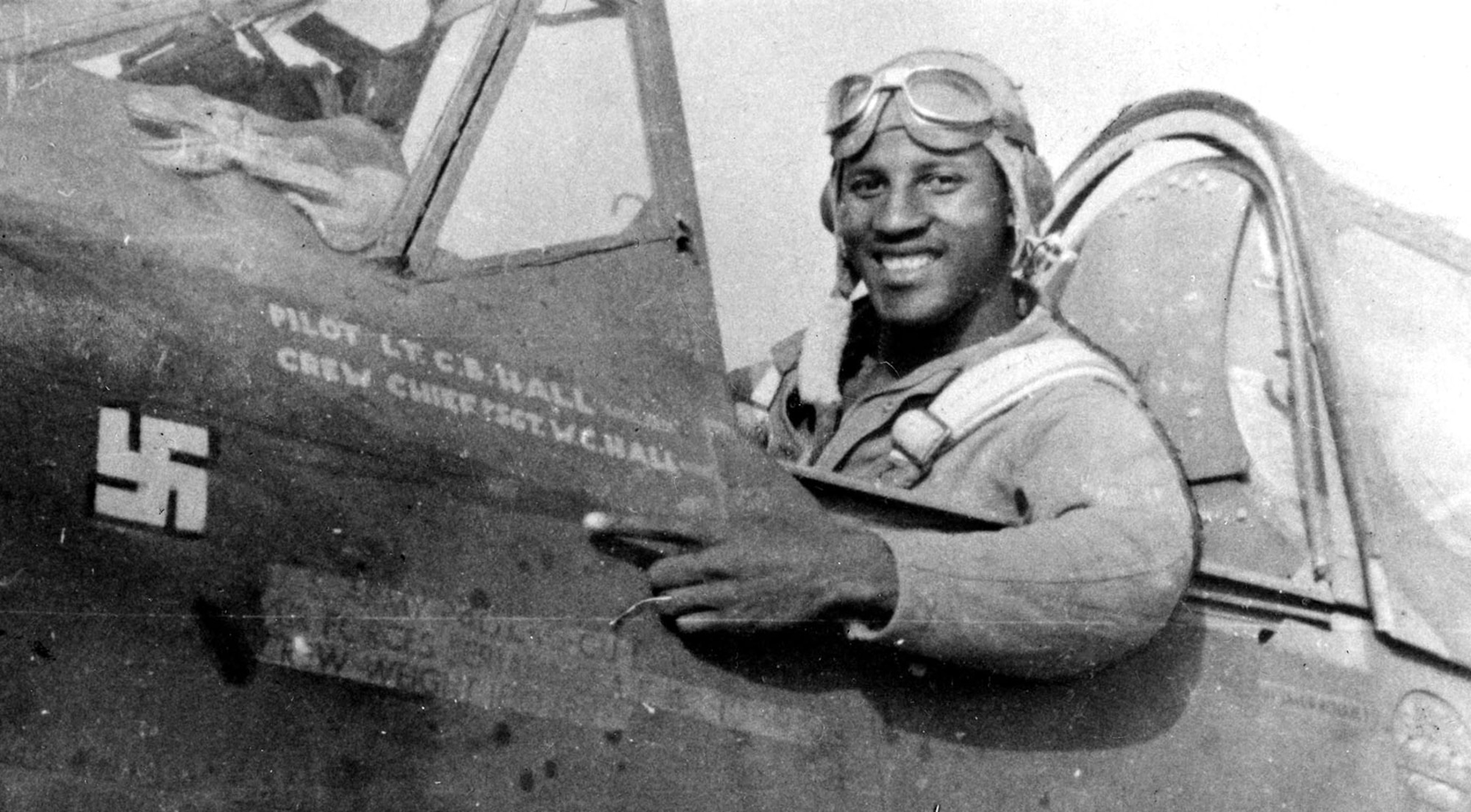 While escorting B-25 Mitchell bombers over Sicily, 1st Lt. (later Maj.) Charles Hall scored the Tuskegee Airmen’s first aerial victory. Seated in the cockpit of his P-40L Warhawk, Hall points to his freshly painted “kill” marking. (U.S. Air Force photo)