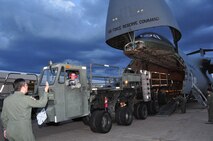 Staff Sgt. Ryan Dane, 73rd Aerial Port Squadron, offloads a Tunner 60k aircraft cargo loader/transporter never before available to the unit providing them a historical training opportunity at Naval Air Station Fort Worth Joint Reserve Base, Texas, Dec. 6, 2014. The 433rd Airlift Wing C-5 from Joint Base San Antonio, Texas, delivered the 60k loader, borrowed from JBSA's 502nd Logistics Readiness Squadron, giving nearly 30 of the 73 APS Airmen combat operational training requirements that are crucial prior to a deployment. (U.S. Air Force photo by Master Sgt. Julie Briden-Garcia)