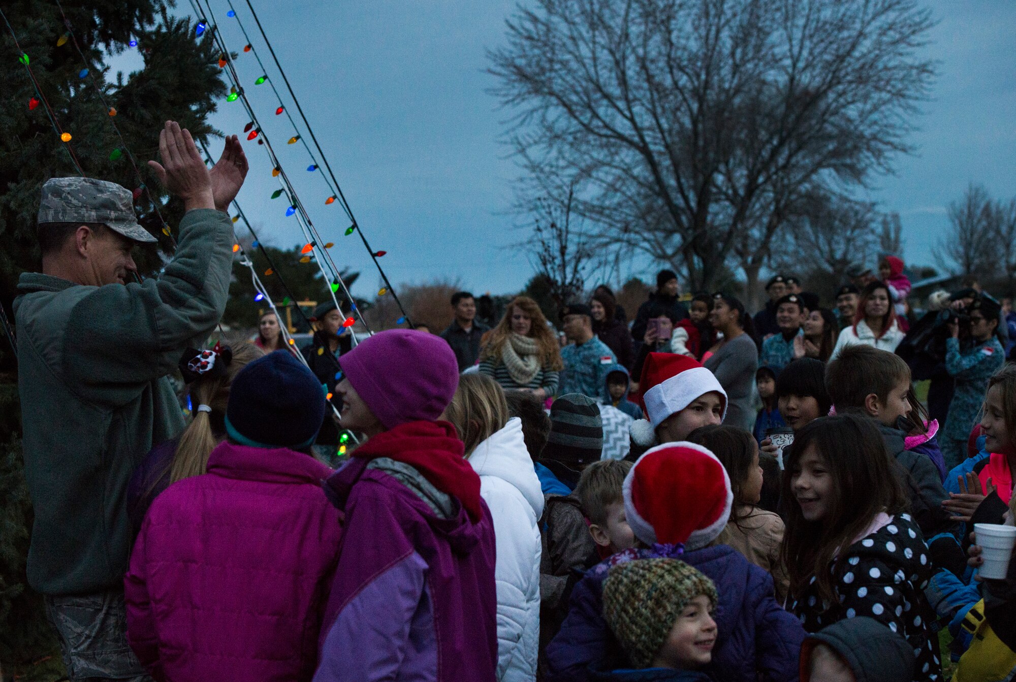 Children celebrate as base leadership lights the Christmas tree at Mountain Home Air Force Base, Idaho, Dec. 5, 2014. Service members and their families gathered at the base chapel where children helped count down for the lighting of the Christmas tree. (U.S. Air Force photo by Airman 1st Class Jessica Smith/RELEASED)