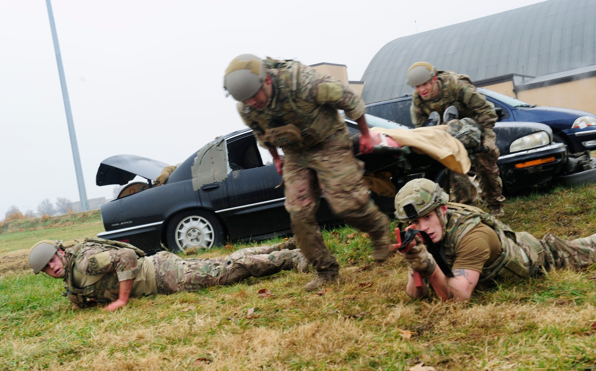 Airmen motion towards the ground as fast as they can after receiving enemy fire while transporting a simulated patient during a Tactical Combat Casualty Care training exercise at Scott Air Force Base, Ill., Dec. 4, 2014. The teams all made up Airmen from the 375th Air Mobility Wing and 932nd Airlift Wing Explosive Ordnance flights had four roles, a medic, medical assistant, a team leader and one security member. There are three parts to TCCC, Care under Fire, Tactical Field Care and Tactical Evacuation Care. Students are taught how to identify three major causes of potentially survivable battlefield injuries — hemorrhage, pneumothorax and blocked airway — and treat them aggressively.   (U.S. Air Force photo/ Staff Sgt. Stephenie Wade)