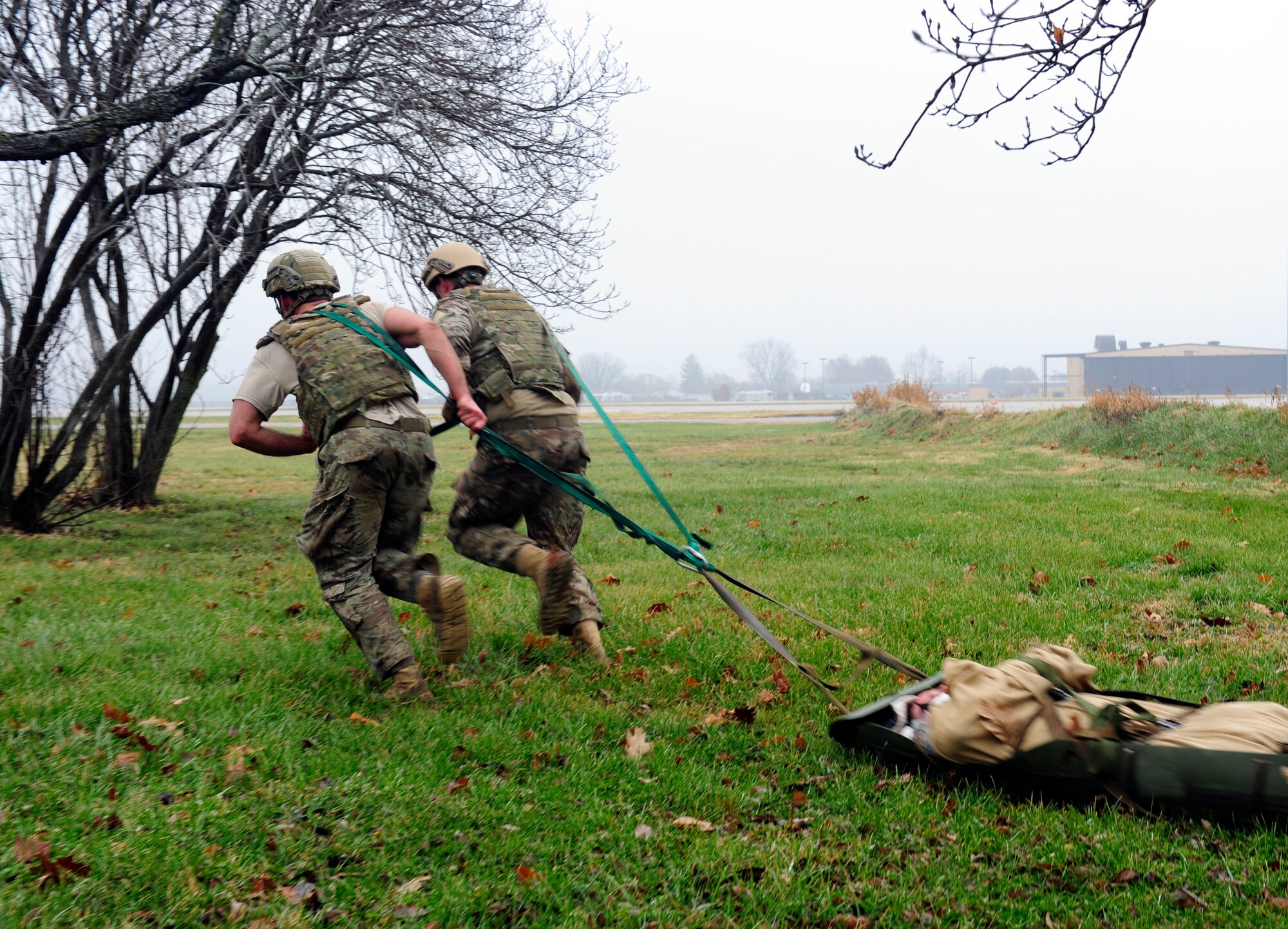 Two Airmen transport a simulated patient during a Tactical Combat Casualty Care training exercise at Scott Air Force Base, Ill., Dec. 4, 2014. The goal of the teams was two get their patients to a location where they would be transported to a higher echelon of care. The teams all made up Airmen from the 375th Air Mobility Wing and 932nd Airlift Wing Explosive Ordnance flights had four roles, a medic, medical assistant, a team leader and one security member. (U.S. Air Force photo/ Staff Sgt. Stephenie Wade)