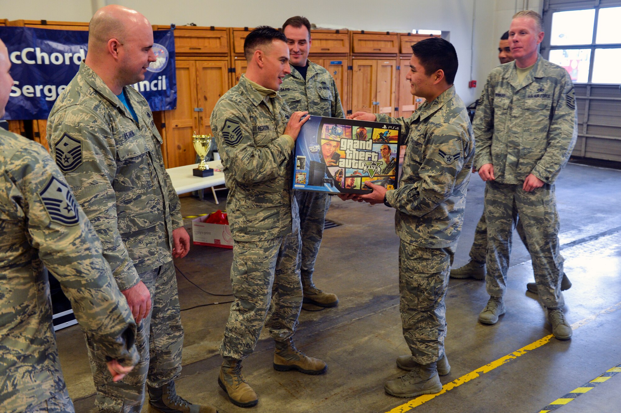 Master Sgt. Jason Redfern, 1st Air Support Operations Group first sergeant, hands a brand new PlayStation 4 to Airman 1st Class Keoni Chavarria, 62nd Airlift Wing public affairs photojournalist, after being the last Airman standing in a game of drill knockout Dec. 5, 2014, during Team McChord’s First Sergeant’s Council Airman’s Feast at Joint Base Lewis-McChord, Wash. The prizes and the free luncheon were provided by the First Sergeants Council to show the Airman their hard work is appreciated and does not go unnoticed. (U.S. Air Force photo/Staff Sgt. Russ Jackson)