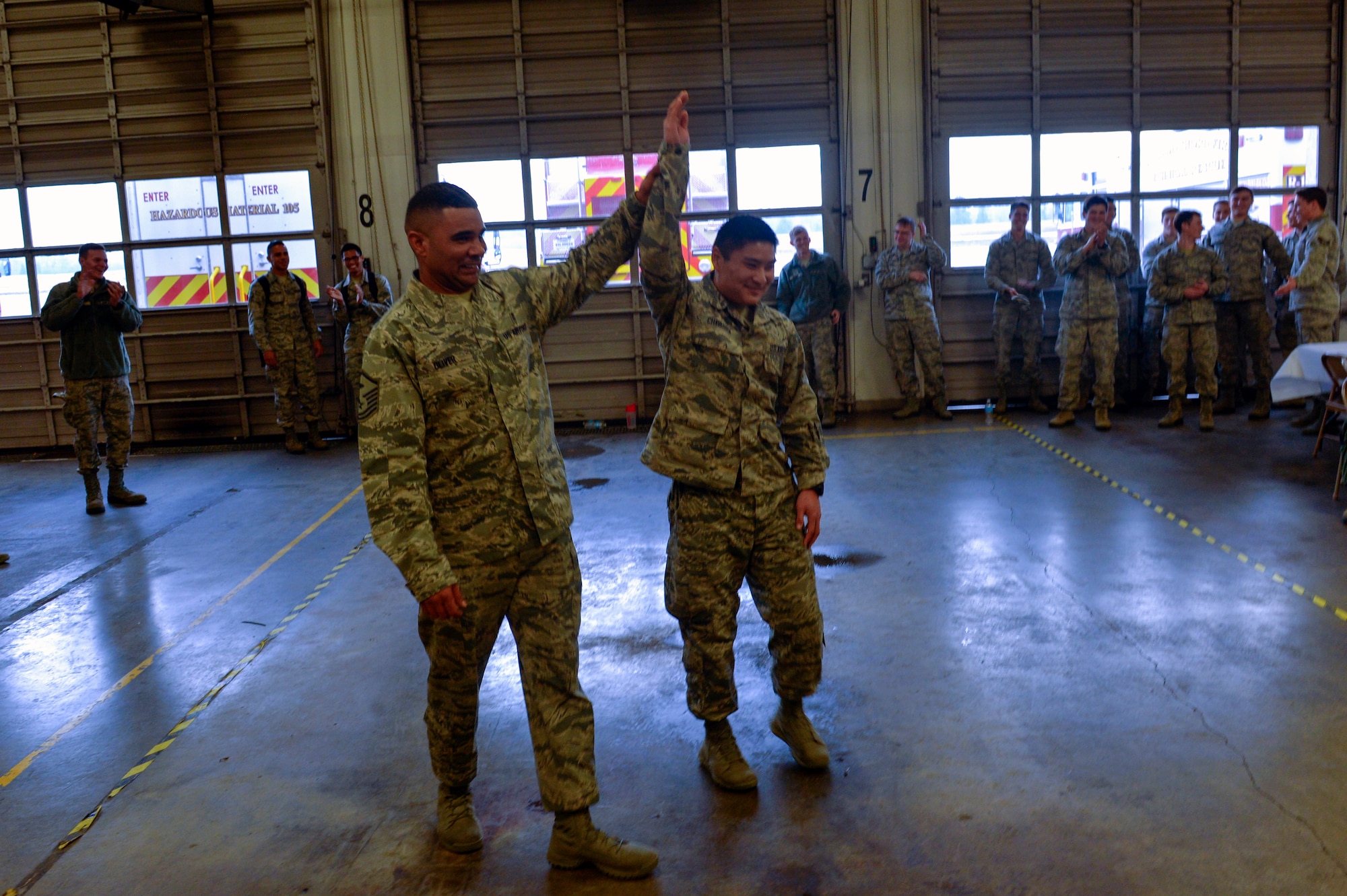 Master Sgt. Calvin Oliver, 62nd Operations Support Squadron first sergeant, hoists the hand of Airman 1st Class Keoni Chavarria, 62nd Airlift Wing public affairs photojournalist, for winning the drill knockout game and the grand prize, a PlayStation 4, Dec. 5, 2014, during Team McChord’s First Sergeant’s Council Airman’s Feast at Joint Base Lewis-McChord, Wash. The crowd, which included members from wing leadership, senior enlisted leaders, and the Pierce Military and Business Alliance erupted with applause after Chavarria had been proclaimed the champion. (U.S. Air Force photo/Staff Sgt. Russ Jackson)