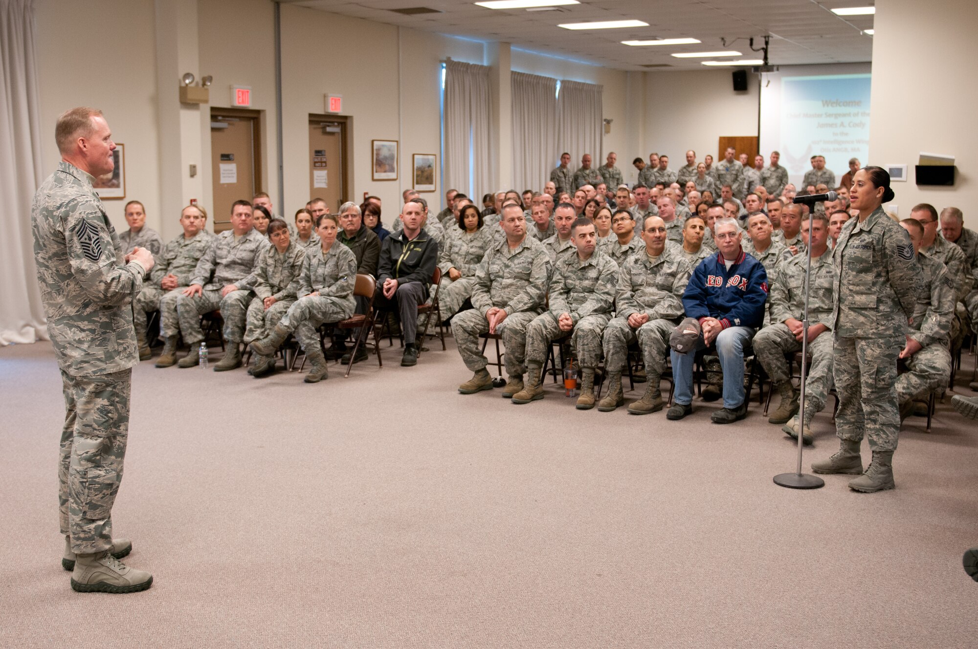 Chief Master Sgt. of the Air Force James A. Cody listens as Technical Sgt. Maria Escobar asks a question during an all-call on Otis Air National Guard Base Nov. 20, 2014. Cody is the first Chief Master Sgt. of the Air Force to visit the base. During his day-long visit Cody learned about the wing’s history, listened to airmen’s concerns, and shared his perspective on a variety of issues affecting the enlisted force. (National Guard photo/Master Sgt. Aaron Smith)