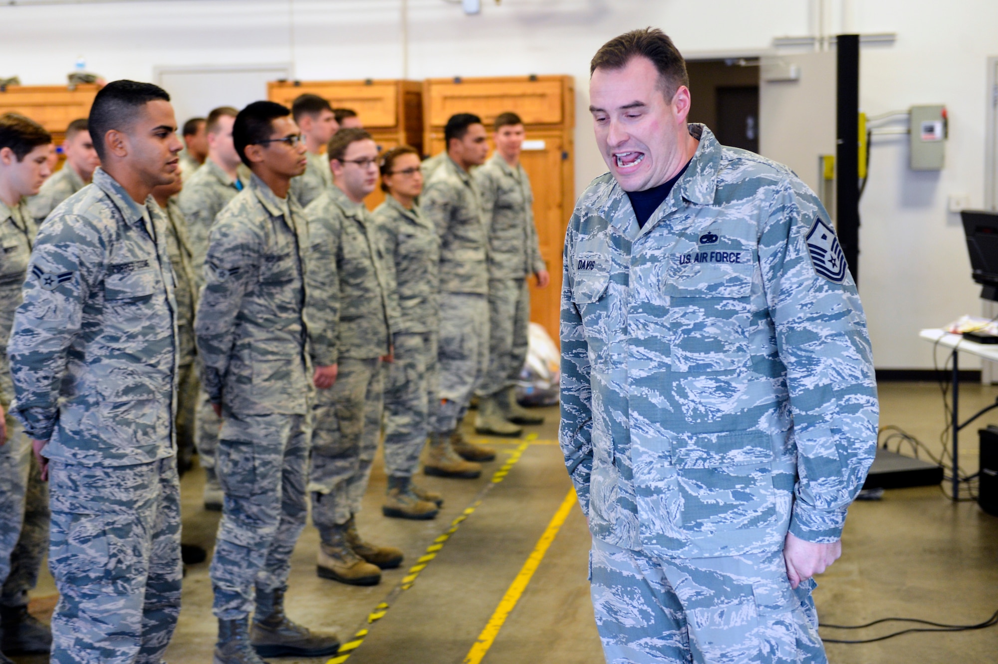 Master Sgt. Curtis Davis, 627 Logistics Readiness Squadron first sergeant, forms a group of Airmen into a formation as they compete for a PlayStation 4, Dec. 5, 2014, during Team McChord’s First Sergeant’s Council Airman’s Feast at Joint Base Lewis-McChord, Wash. Davis, a former military training instructor barked out drill commands at the Airmen and those who made incorrect movements were disqualified from winning the grand prize. (U.S. Air Force photo/Staff Sgt. Russ Jackson)