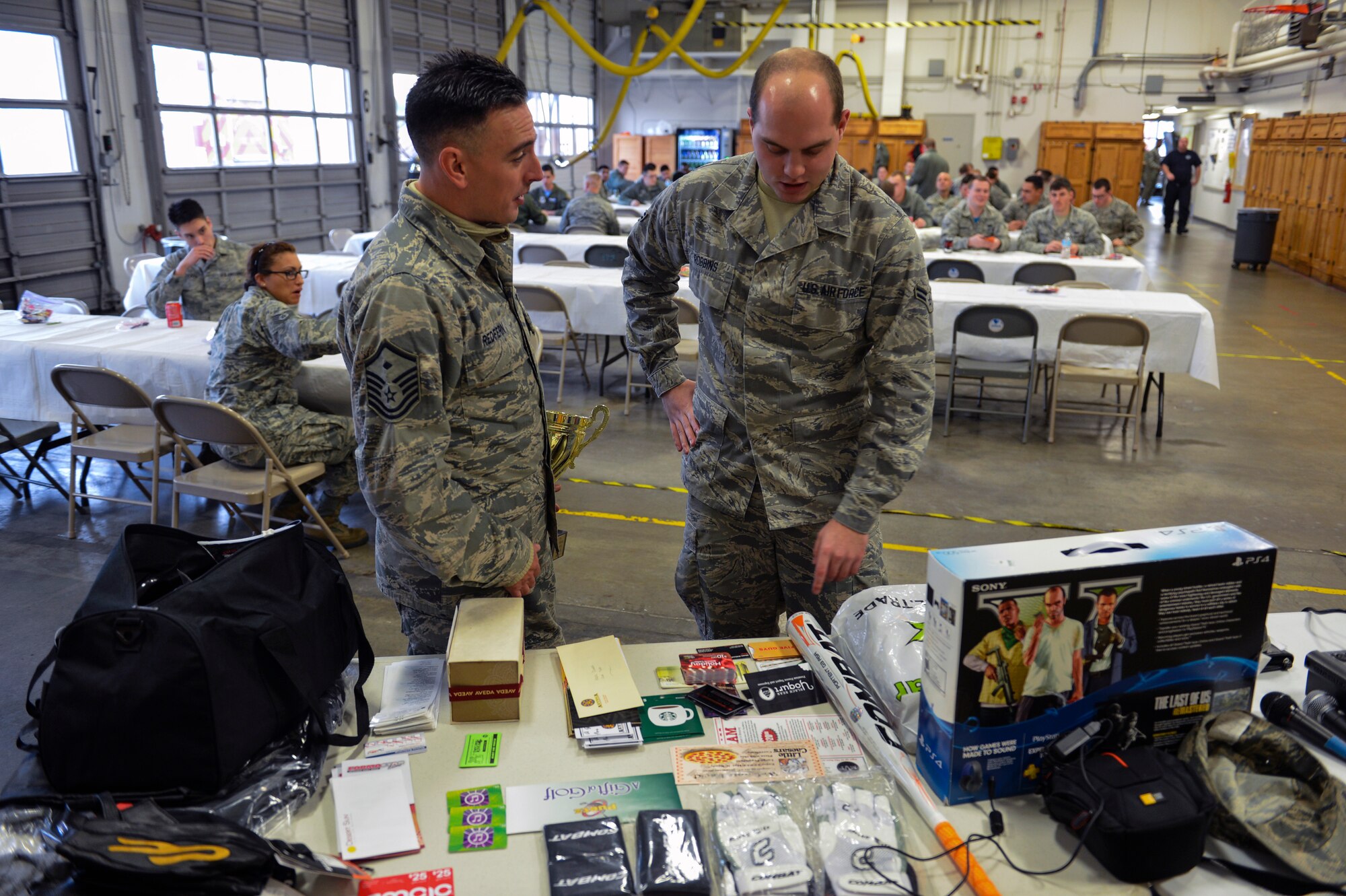 Master Sgt. Jason Redfern, 1st Air Support Operations Group first sergeant, offers Airman First Class Kevin Robbins from the 62nd Maintenance Group, his choice of raffle prizes after his ticket number was called Dec. 5, 2014, during Team McChord’s First Sergeant’s Council Airman’s Feast at Joint Base Lewis-McChord, Wash. Prizes included gift certificates to numerous restaurants, motorcycle gear, a softball bat and gloves, workout equipment, and classic gaming systems like a Super Nintendo and Sega Genesis. (U.S. Air Force photo/Staff Sgt. Russ Jackson)