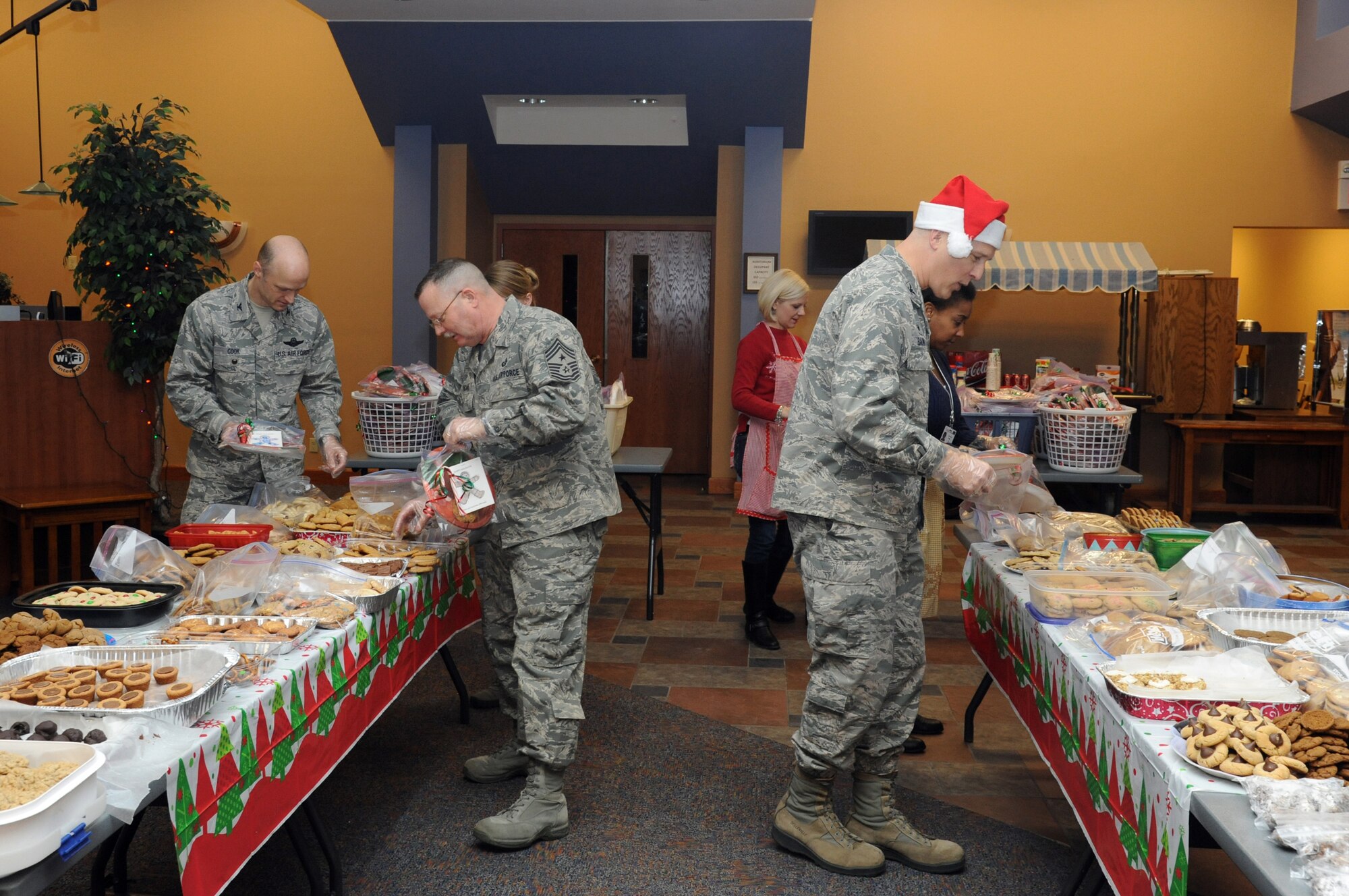 319th Air Base Wing leadership and members of the 319th ABW Key Spouses Club start assembling cookie platters for dormitory residents during the annual Holiday Cookie Drive on Grand Forks Air Force Base, N.D., Dec. 8, 2014. More than 500 dozen cookies were donated for delivery to young Airmen. (U.S. Air Force photo/Staff Sgt. David Dobrydney)