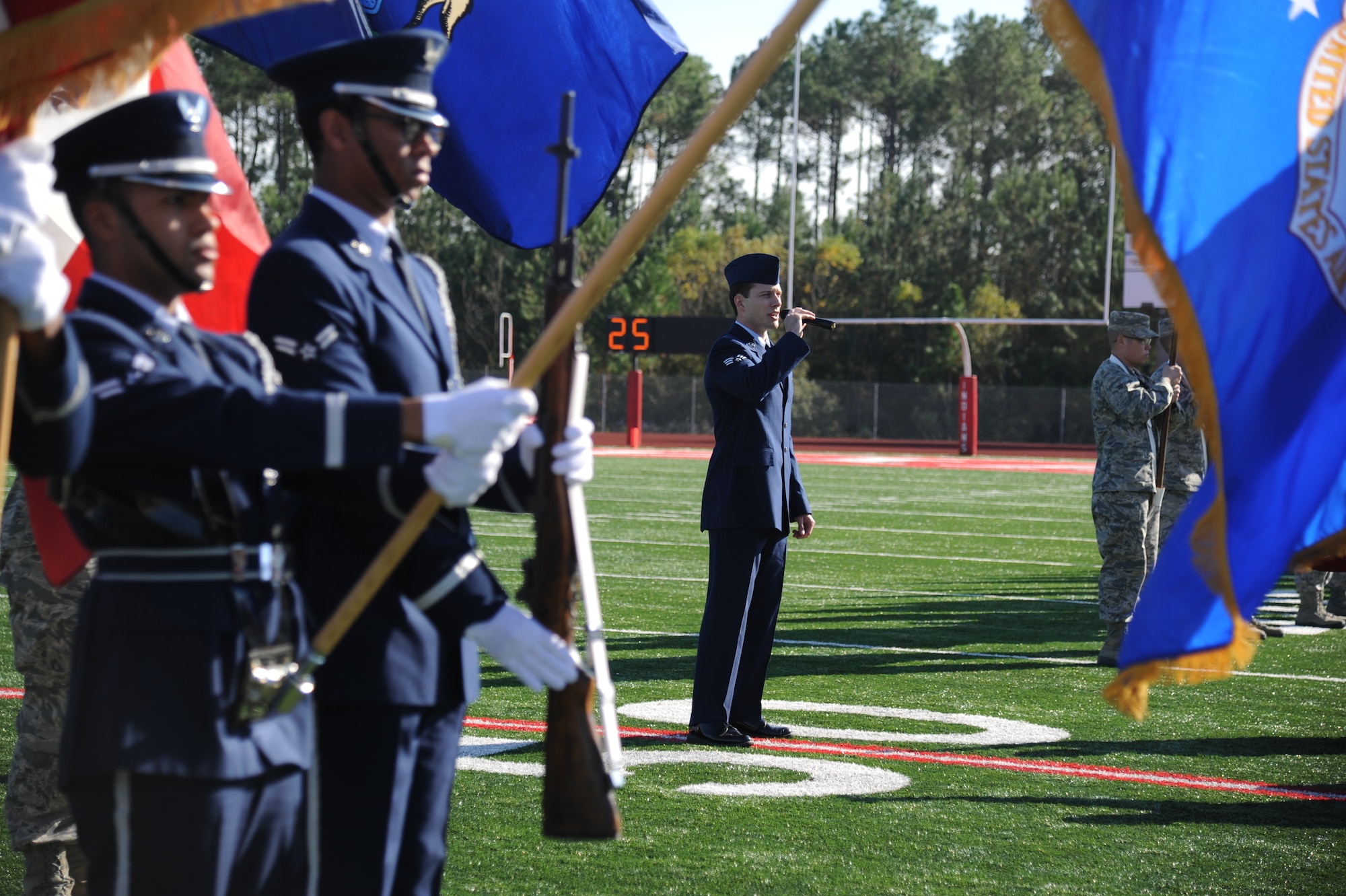 Senior Airman Robert DeSantis, 81st Medical Group aerospace medical technician, sings the National Anthem during the 2014 Mississippi Bowl Dec. 7, 2014, at the Biloxi High School Football Stadium. Brig. Gen. Patrick Higby, 81st Training Wing commander, the Keesler Honor Guard and Airmen carrying the 50-State flags also participated in the pre-game celebration. (U.S. Air Force photo by Kemberly Groue)