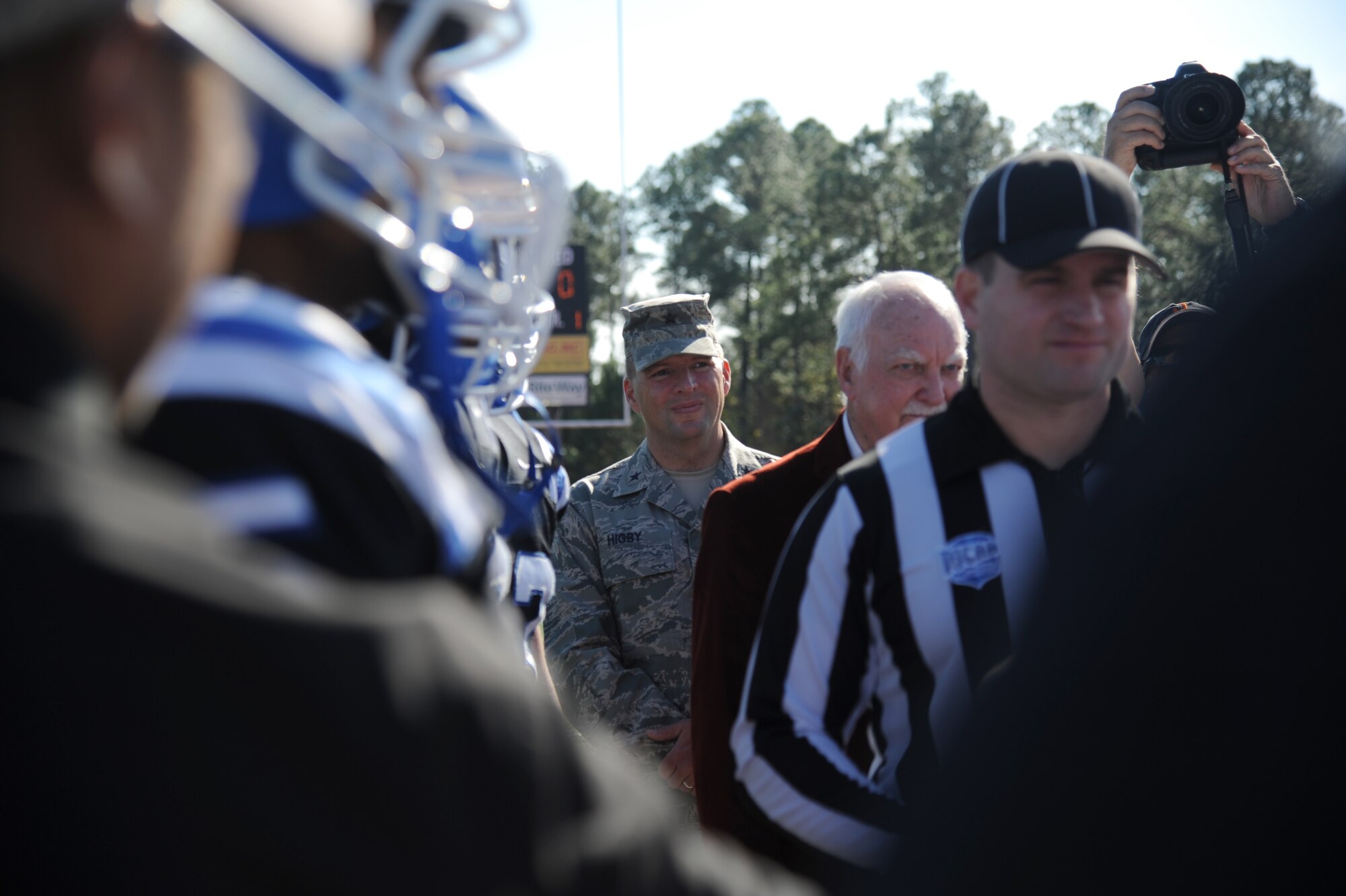 Brig. Gen. Patrick Higby, 81st Training Wing commander, joins referees and team captains for the official coin toss during the 2014 Mississippi Bowl Dec. 7, 2014, at the Biloxi High School Football Stadium. The Keesler Honor Guard and Airmen carrying the 50-State flags also participated in the pre-game celebration. (U.S. Air Force photo by Kemberly Groue)