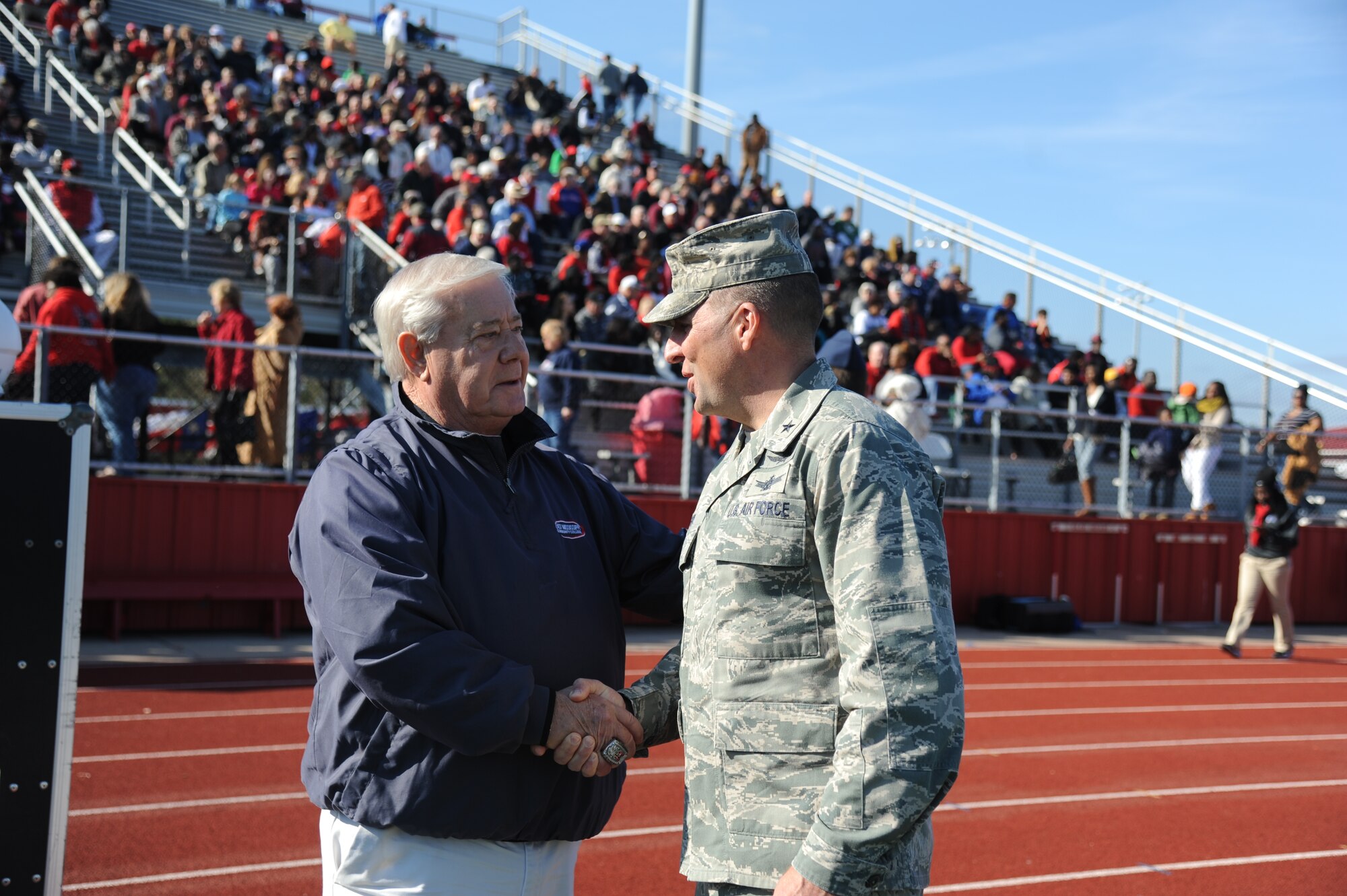 Randy Rigdon, East Mississippi Community College alumni, greets Brig. Gen. Patrick Higby, 81st Training Wing commander, during the 2014 Mississippi Bowl Dec. 7, 2014, at the Biloxi High School Football Stadium. Higby participated in the coin toss during the pre-game celebration. (U.S. Air Force photo by Kemberly Groue)
