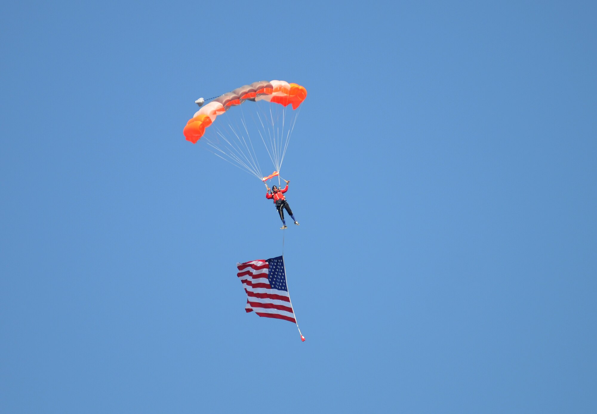 Vincent Moore, American Skydiving Team, makes his way to the Biloxi High School Football Stadium with the U.S. flag during the 2014 Mississippi Bowl Dec. 7, 2014. Brig. Gen. Patrick Higby, 81st Training Wing commander, the National Anthem singer, the Keesler Honor Guard and Airmen carrying the 50-State flags also participated in the pre-game celebration.  (U.S. Air Force photo by Kemberly Groue)