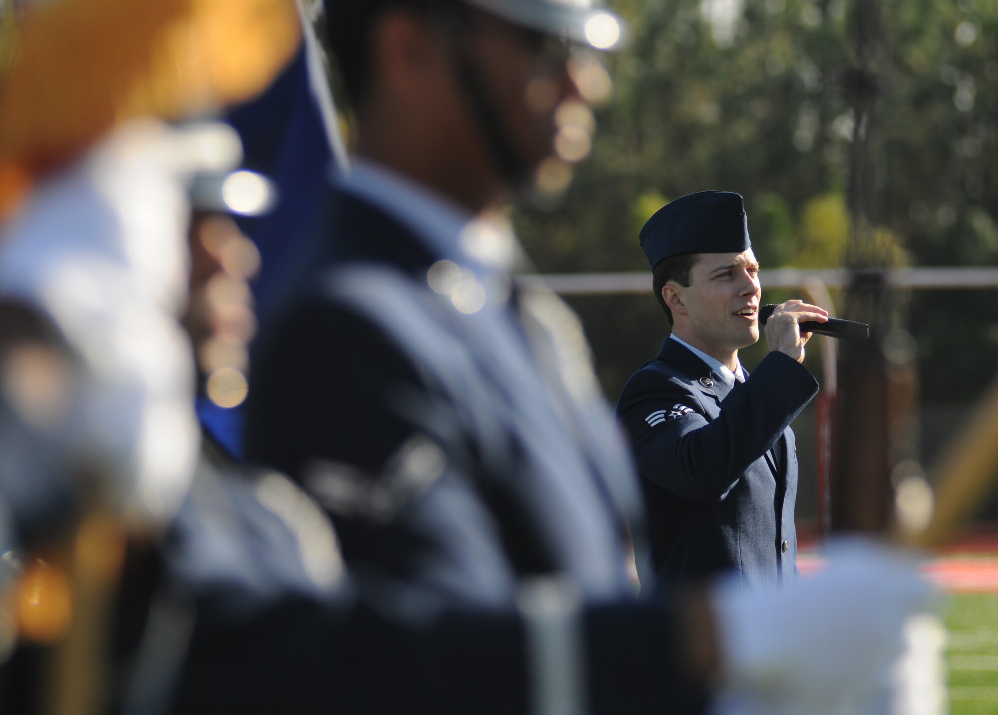 Senior Airman Robert DeSantis, 81st Medical Group, sings the National Anthem during the 2014 Mississippi Bowl Dec. 7, 2014, at the Biloxi High School Football Stadium. Brig. Gen. Patrick Higby, 81st Training Wing commander, the Keesler Honor Guard and Airmen carrying the 50-State flags also participated in the pre-game celebration.  (U.S. Air Force photo by Kemberly Groue)
