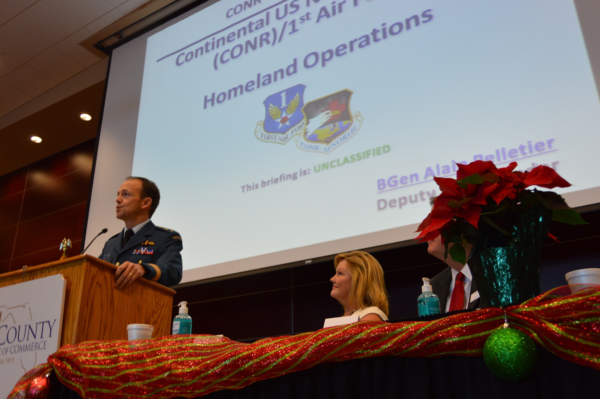 BGen Alain Pelletier, (right) Continental U.S. North American Aerospace Defense Region Deputy Commander presents a briefing Dec. 5 about the NORAD Tracks Santa program and the CONR mission overall at First Friday, a Bay County Chamber of Commerce monthly event . The event is attended by civic leaders and business owners from throughout Bay County. (Photo by Mary McHale)