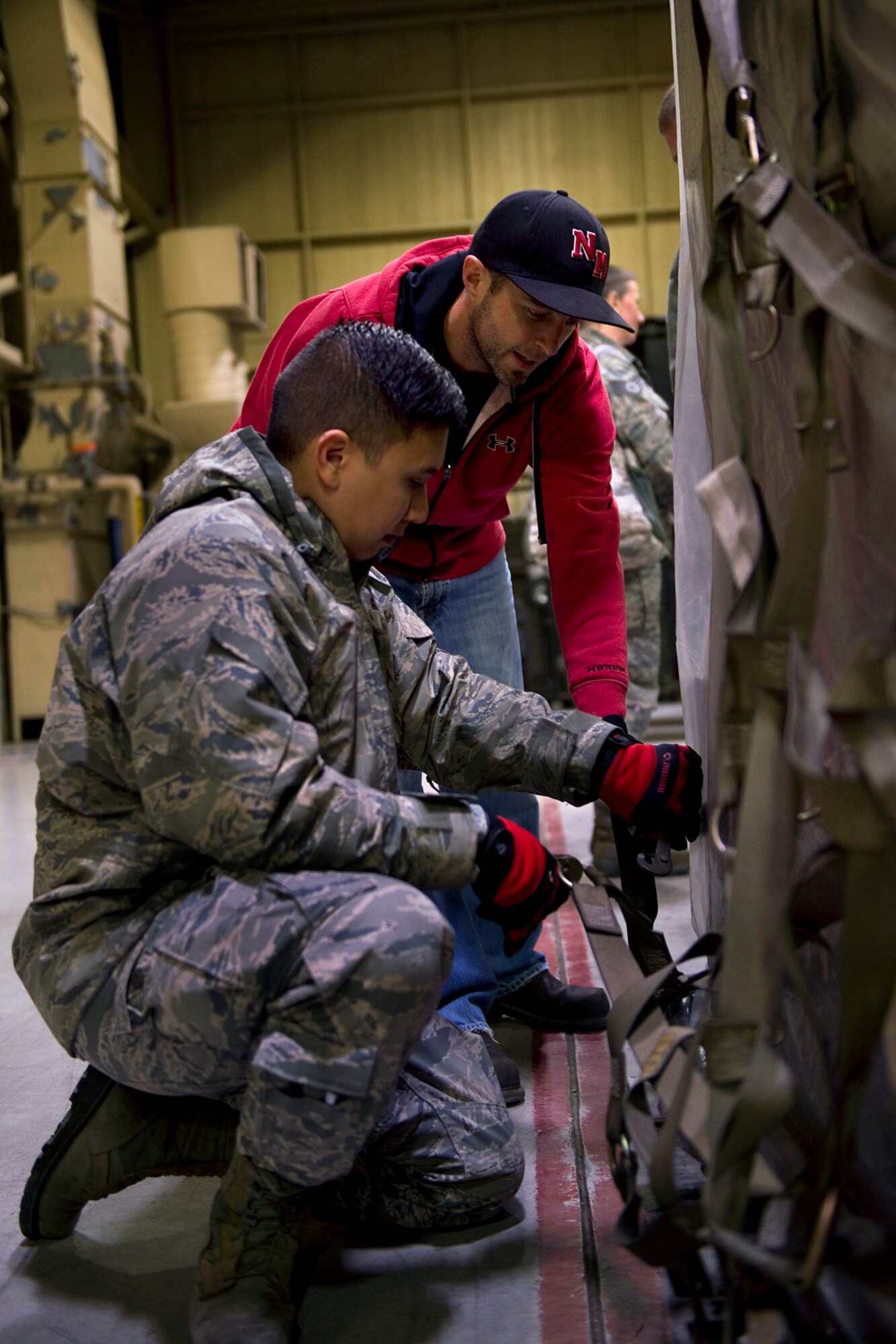 Brian Wright, 434th ARW contracted combat readiness resource specialist, assists Senior Airmen Mark Collofello, 434th Aircraft Maintenance Squadron crew chief, with proper tie-down techniques to restrain cargo on a pallet at Grissom Air Reserve Base, Ind., Nov. 1, 2014. The techniques were taught during a pallet building course that trains Airmen on proper ways of loading cargo onto an aircraft using a combination of geometry, algebra and tie-down techniques.  (U.S. Air Force photo/Staff Sgt. Benjamin Mota)