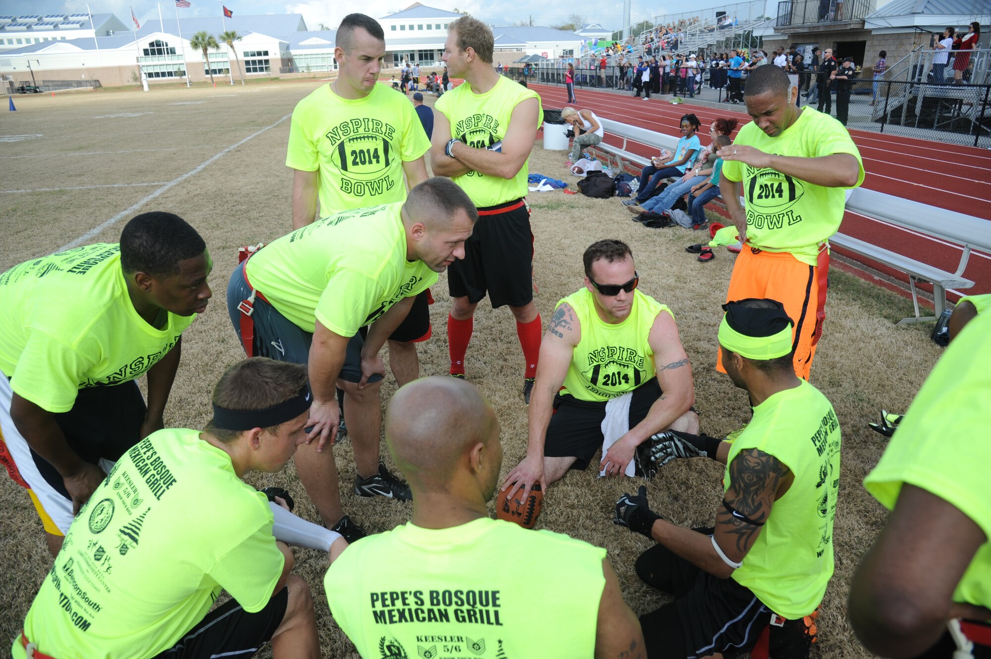 The Joint Branch team discusses game strategies during half time against the Mississippi Gulf Coast team during the Nspire Bowl Dec. 6, 2014, at the Salvation Army Kroc Center, Biloxi, Miss.  The Nspire Bowl is a charity event that included two flag-football games with teams made up of military personnel and civilians from local communities.  All donations and profits from the event will be used to purchase gifts for the Salvation Army Angel Tree program. (U.S. Air Force photo by Kemberly Groue)