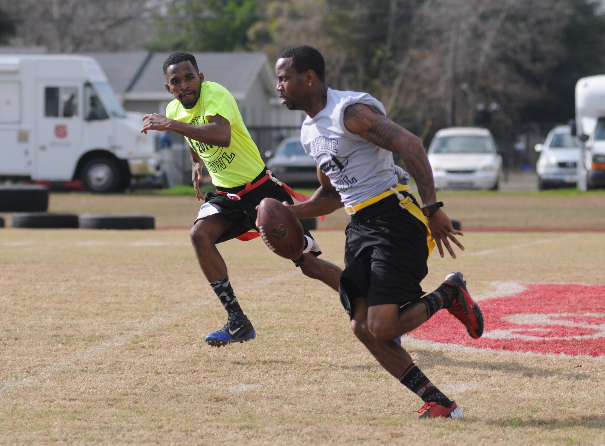Senior Airman Quaci Allen, 81st Inpatient Operation Squadron labor and delivery medical technician and Joint Branch team, closes in as Jason Armstead of Moss Point as the Mississippi Gulf Coast team runs the ball during the Nspire Bowl Dec. 6, 2014, at the Salvation Army Kroc Center, Biloxi, Miss.  The Nspire Bowl is a charity event that included two flag-football games with teams made up of military personnel and civilians from local communities.  All donations and profits from the event will be used to purchase gifts for the Salvation Army Angel Tree program. (U.S. Air Force photo by Kemberly Groue)