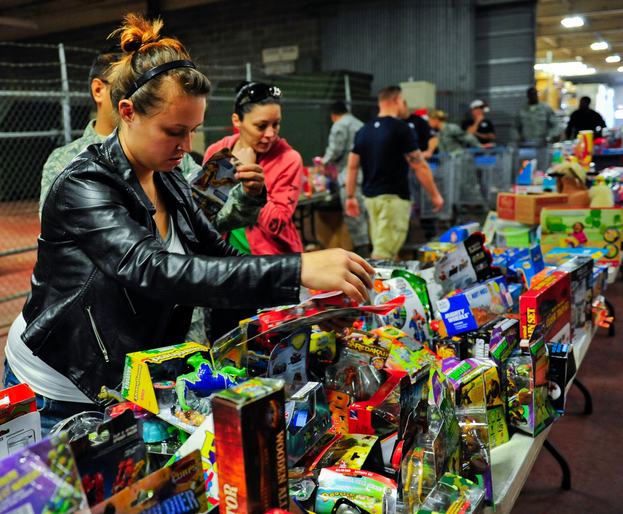 A parent looks over toys during the 11th annual toy distribution at Eglin Air Force Base, Fla. Dec. 5. Approximately 2,000 toys were collected by donations made throughout the year. Toys, bikes, books, games, crafts, sports equipment and stuffed animals were given to active-military families in need of assistance during the holidays. (U.S. Air Force photo/Ilka Cole)