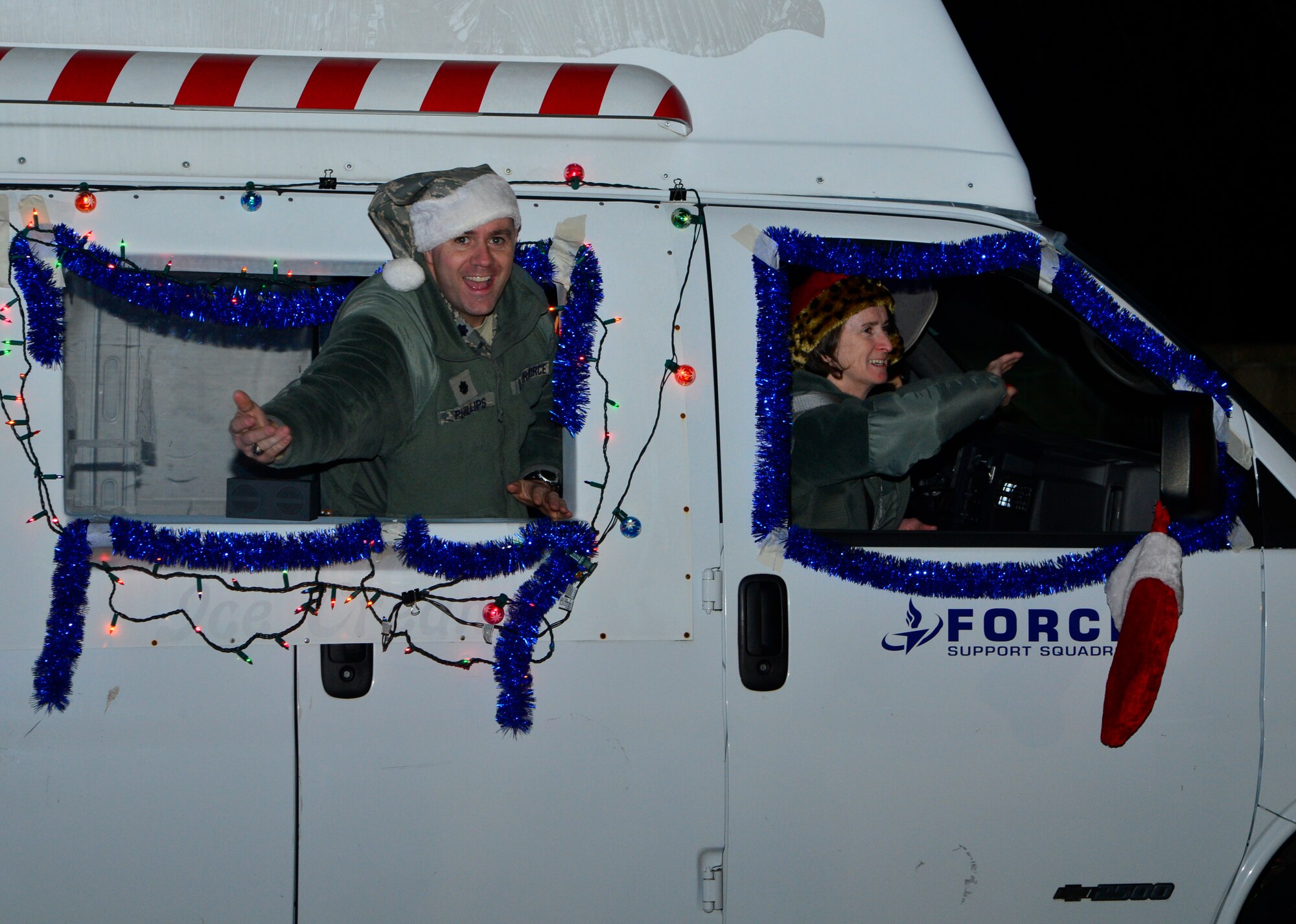 Lt. Col. Michael Philips, 436th Mission Support Group deputy commander, throws candy to spectators during the Christmas parade Dec. 4, 2014, at Dover Air Force Base, Del. The parade featured decorated floats from squadrons and the parade ended with a tree lighting ceremony at the base housing chapel. (U.S. Air Force photo/Airman 1st Class William Johnson)