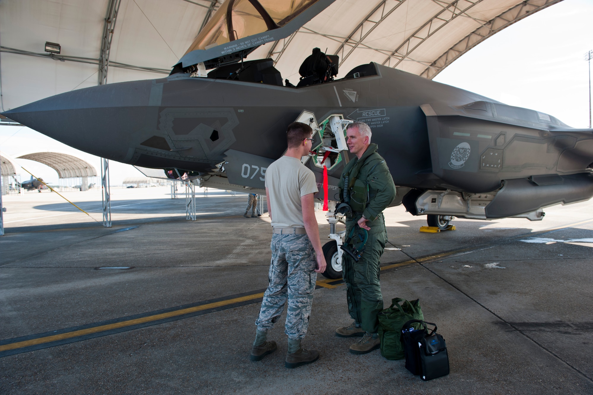 Airman 1st Class Johnny Patterson, left, 58th Aircraft Maintenance Squadron F-35 Lightning II crew chief, talks to Col. Charles Wallace II, 33rd Fighter Wing F-35 Academic Training Center director and F-35 pilot, after completing his first sortie in the aircraft on Eglin Air Force Base, Fla., Dec. 5, 2014. Patterson was in the first class of pipeline students qualified as F-35 Lightning II crew chiefs. While other crew chiefs on the flight line cross-trained from fourth-generation weapon systems, Patterson’s class has only ever worked with the F-35. (U.S. Air Force photo/Staff Sgt. Marleah Robertson)