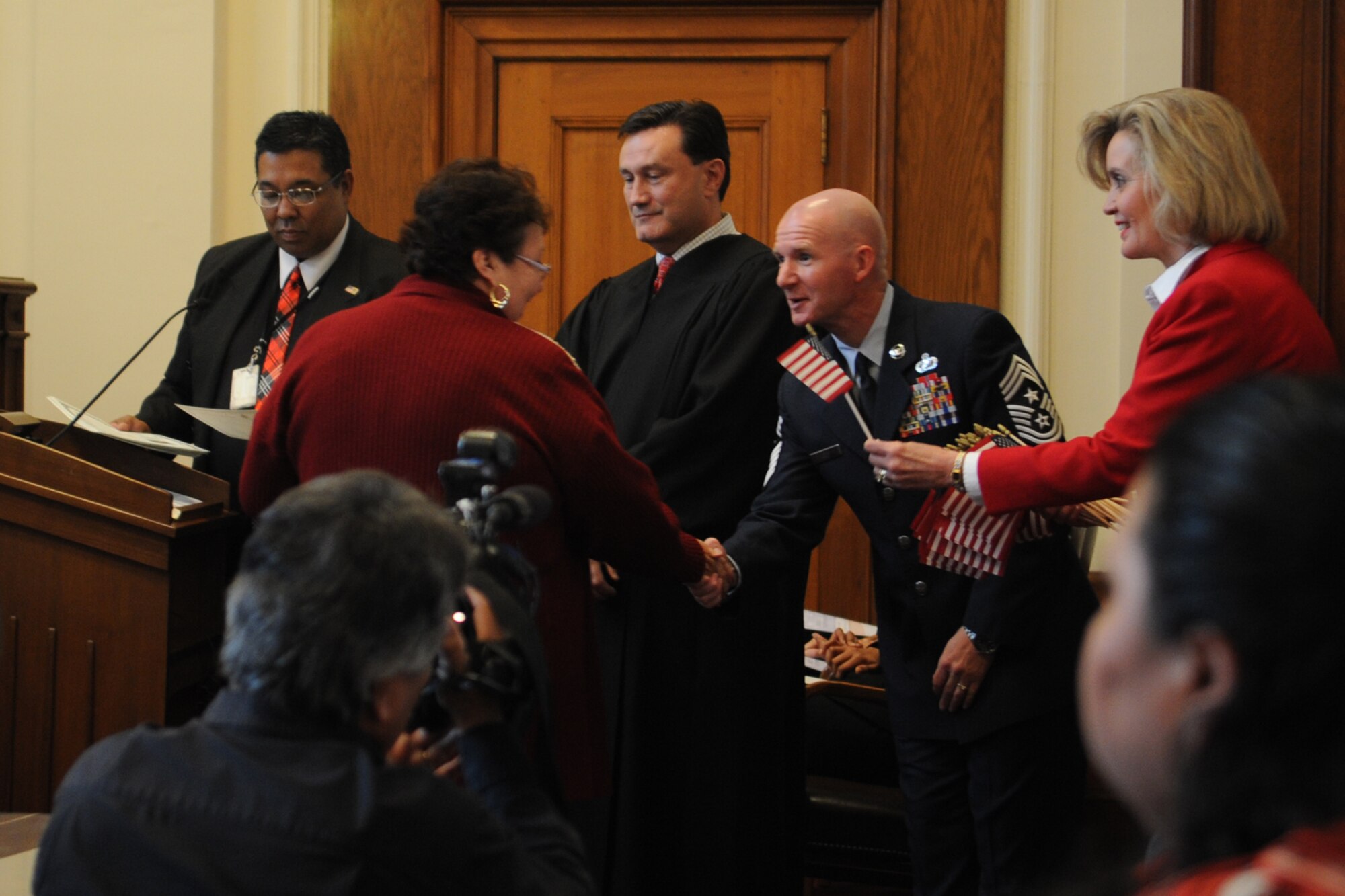 SAN ANGELO, Texas -- Chief Master Sgt. Thomas F. Good, 17th Training Wing Command Chief, shakes the hand of a new U.S. citizen at a naturalization ceremony in the O. C. Fisher Federal Building Dec. 3. Good was the featured speaker at the ceremony. (U.S. Air Force photo/ Staff Sgt. Laura R. McFarlane)