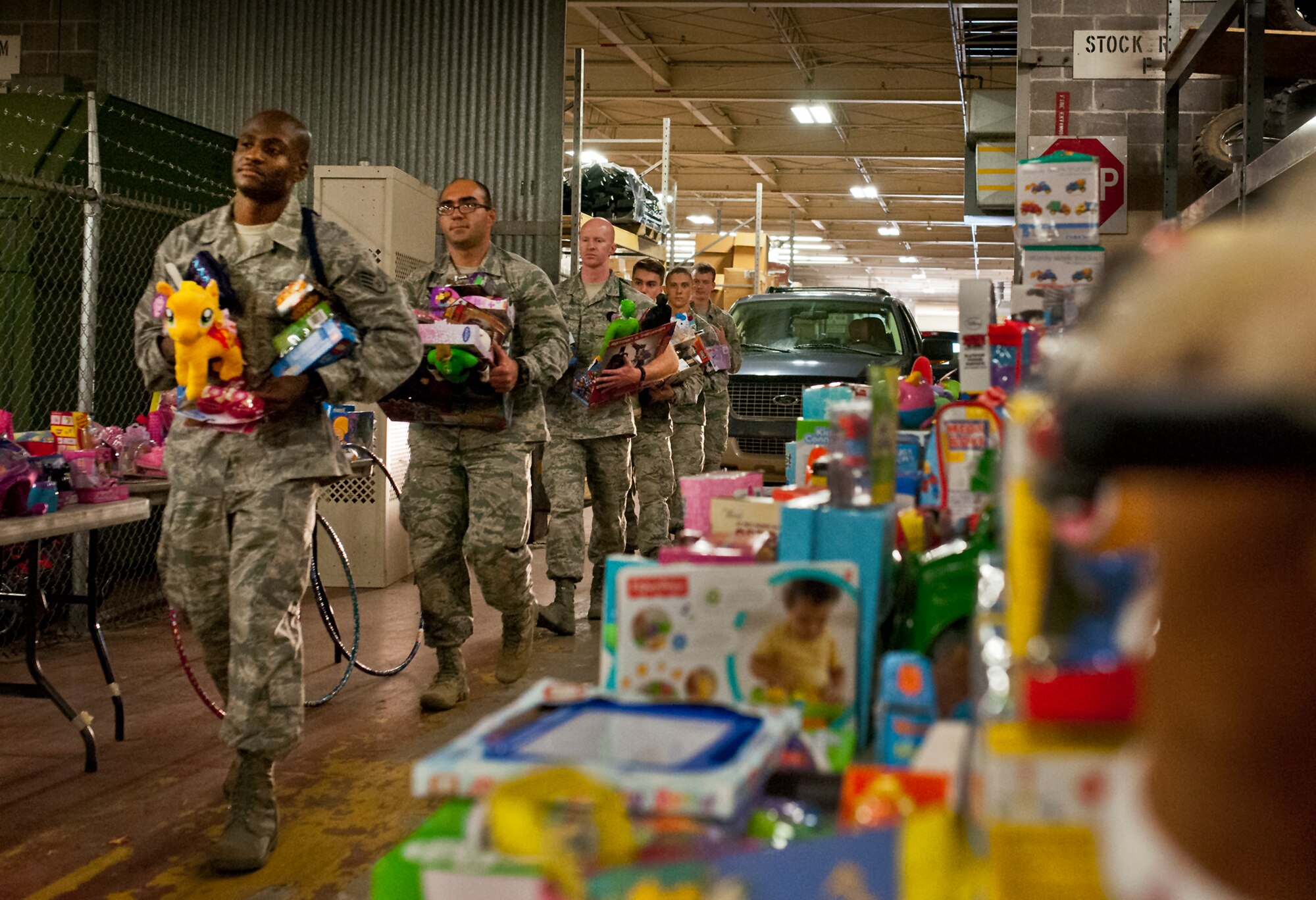 A line of Air Force explosive ordnance disposal students drop off toys for the base’s annual toy distribution drive Dec. 4 at Bldg. 615 on Eglin Air Force Base, Fla.  More than 200 active duty members and their families picked out the toys, books and bikes Dec. 5-6.  (U.S. Air Force photo/Samuel King Jr.)