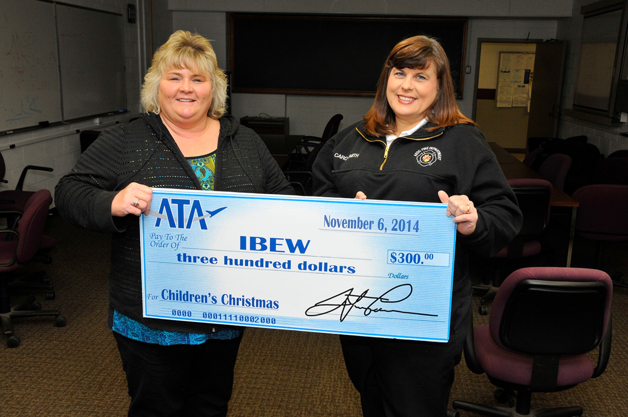 Aerospace Testing Alliance (ATA) recently made a donation to the International Brotherhood of Electrical Workers 2113 (IBEW) for the Kids for Christmas event, which enables foster children to go Christmas shopping and purchase gifts for their loved ones. Pictured is Annette Painter (left), financial secretary for IBEW, accepting the donation from Carol Smith (right), administrative assistant for the Arnold Engineering Development Complex (AEDC) Fire Department and representative of the ATA Employee and Community Activities Committee. (Photo by Rick Goodfriend)