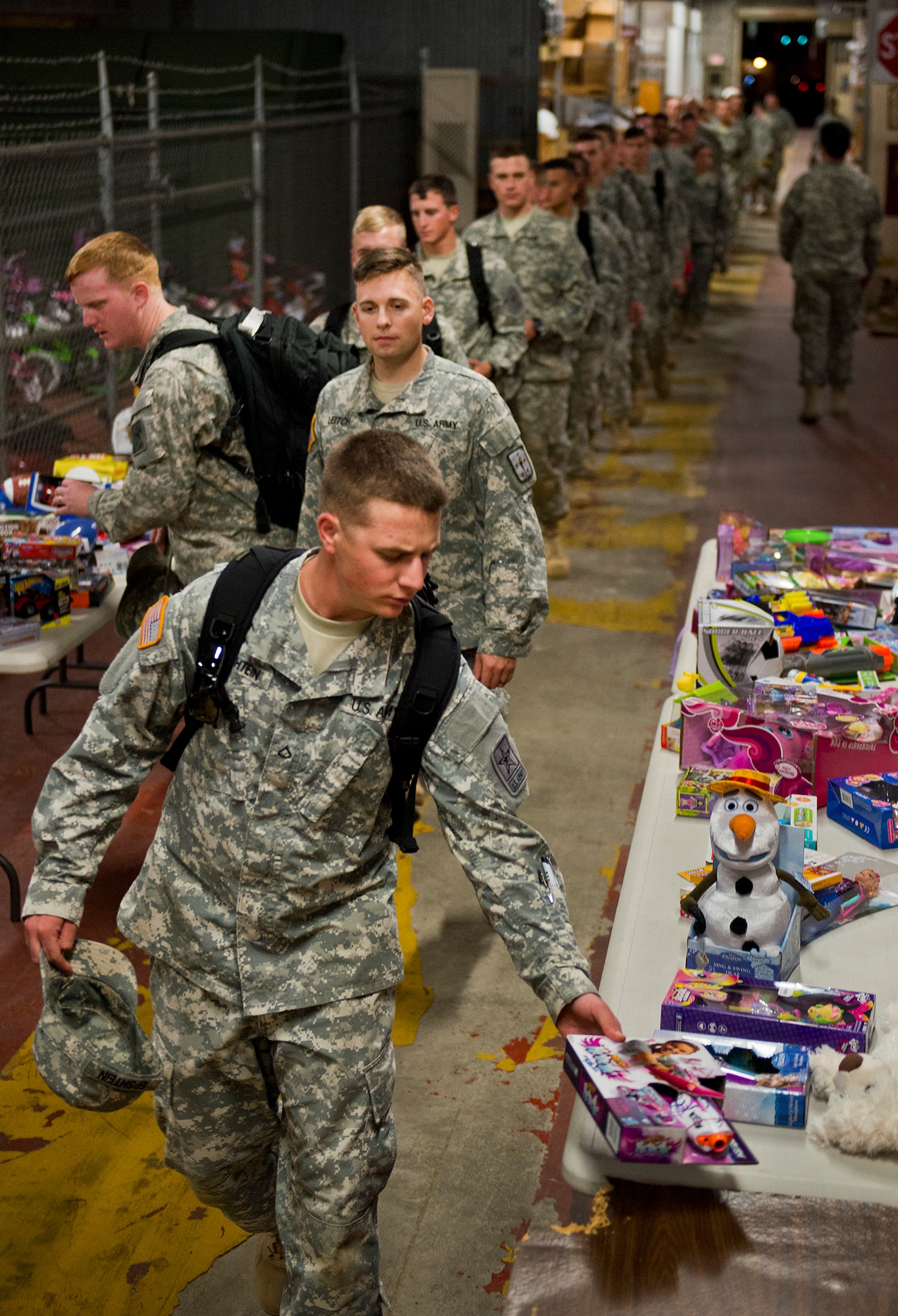 A line of Army explosive ordnance disposal students drop off toys for the base’s annual toy distribution drive Dec. 2 at Bldg. 615 on Eglin Air Force Base, Fla.  More than 200 active duty members and their families picked out the toys, books and bikes Dec. 5-6.  (U.S. Air Force photo/Samuel King Jr.)