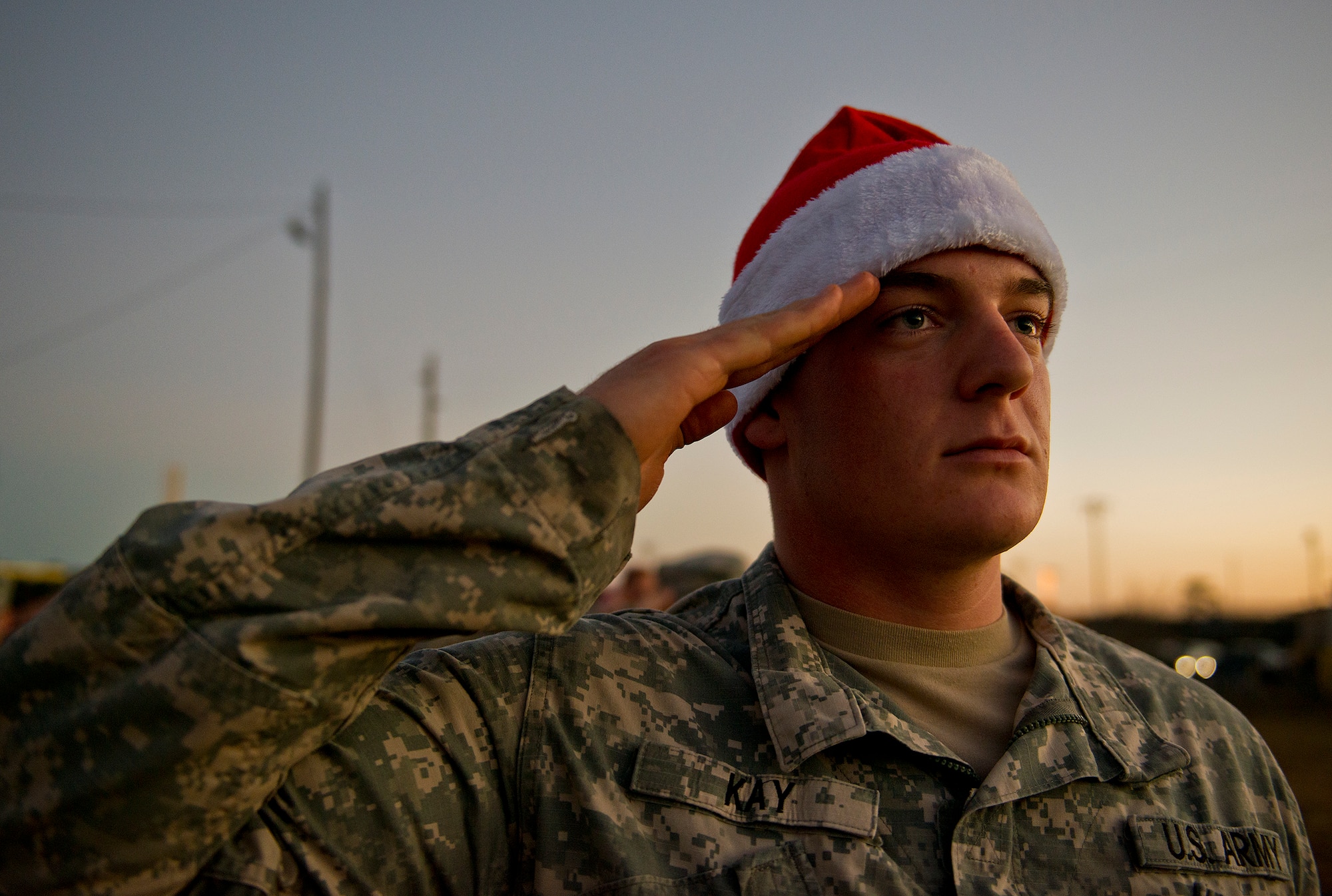 An Army explosive ordnance disposal student salutes during the National Anthem prior to the group marching to Bldg. 615 to deliver toys for the base’s annual toy distribution drive Dec. 2 at Eglin Air Force Base, Fla.  More than 200 active duty members and their families picked out the toys, books and bikes Dec. 5-6.  (U.S. Air Force photo/Samuel King Jr.)
