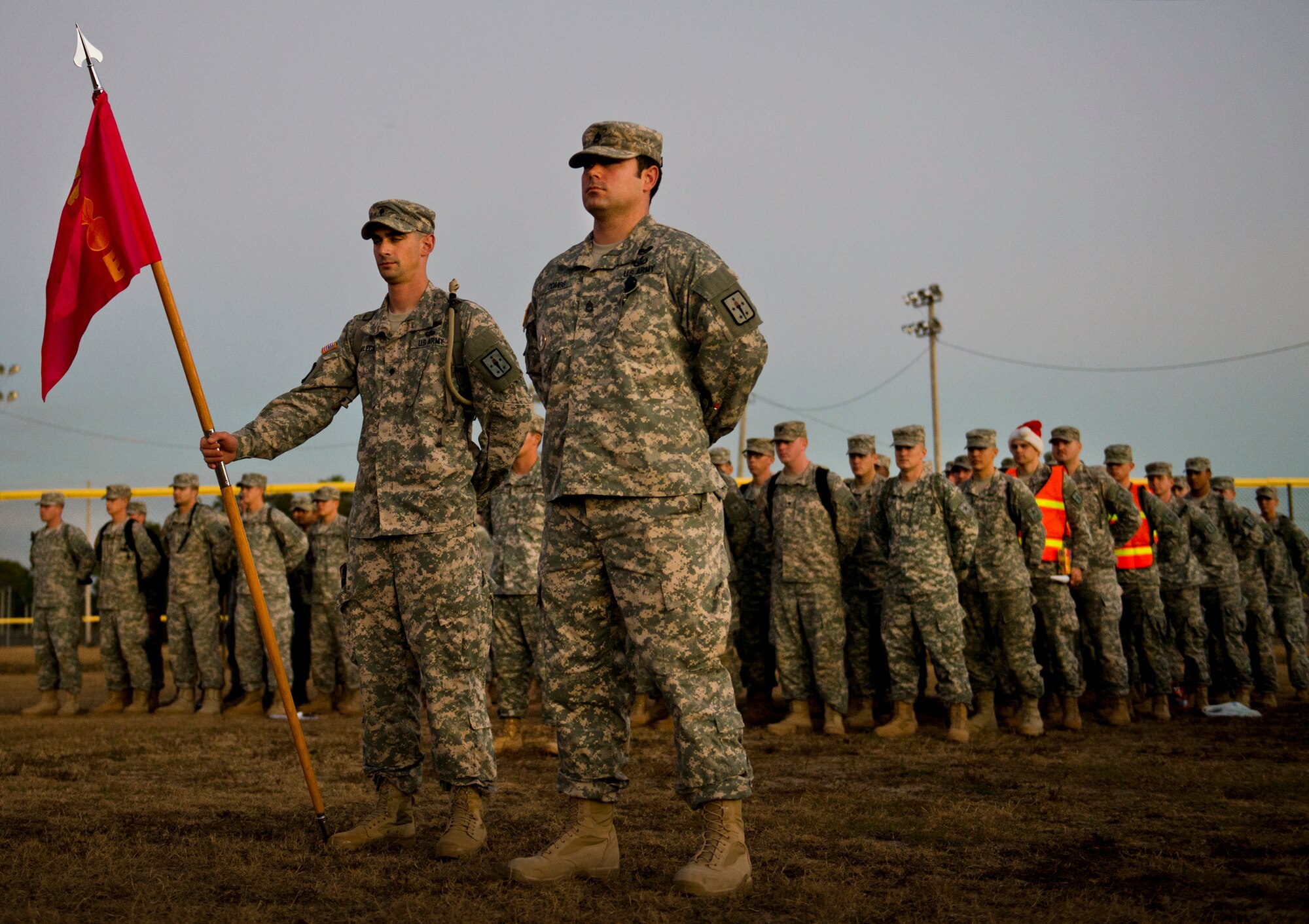 An Army explosive ordnance disposal student formation stands ready to salute the National Anthem prior to the group marching to Bldg. 615 to deliver toys for the base’s annual toy distribution drive Dec. 2 at Eglin Air Force Base, Fla.  More than 200 active duty members and their families picked out the toys, books and bikes Dec. 5-6.  (U.S. Air Force photo/Samuel King Jr.)
