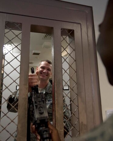 Staff  Sgt. Jonathan Breed, 628th Security Forces Squadron Armory assistant NCOIC, safely transfers an M-4 carbine to a patrolman Dec. 3, 2014, at Joint Base Charleston, S.C. Armorers safe house firearms, ammunition, night vision goggles, and other tactical gear used by the 628th SFS. (U.S. Air Force photo/Senior Airman Jared Trimarchi) 